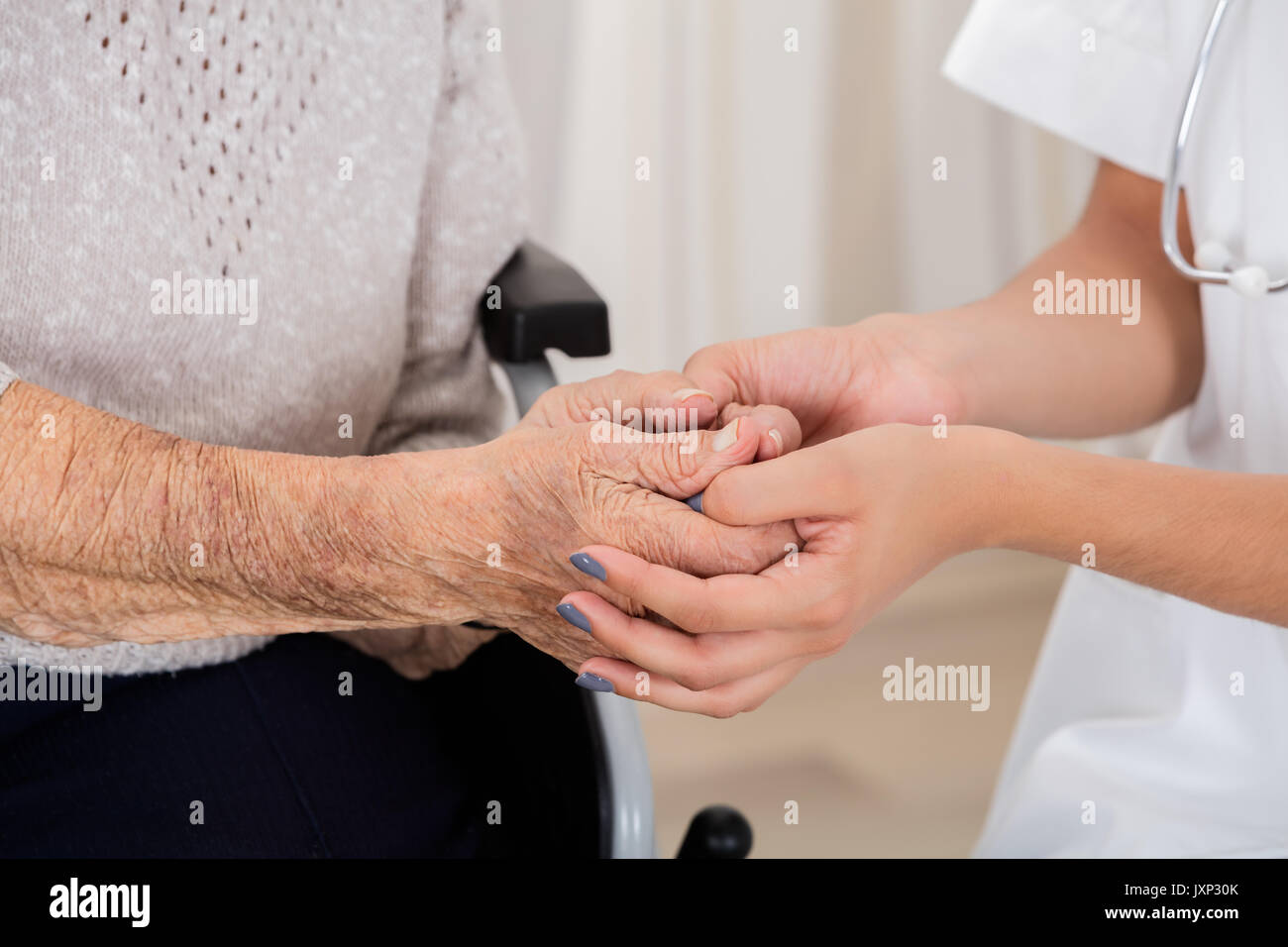 In der Nähe der weiblichen Doktor die Hand des älteren Patienten Stockfoto In der Nähe der weiblichen Doktor die Hand des älteren Patienten Stockfoto