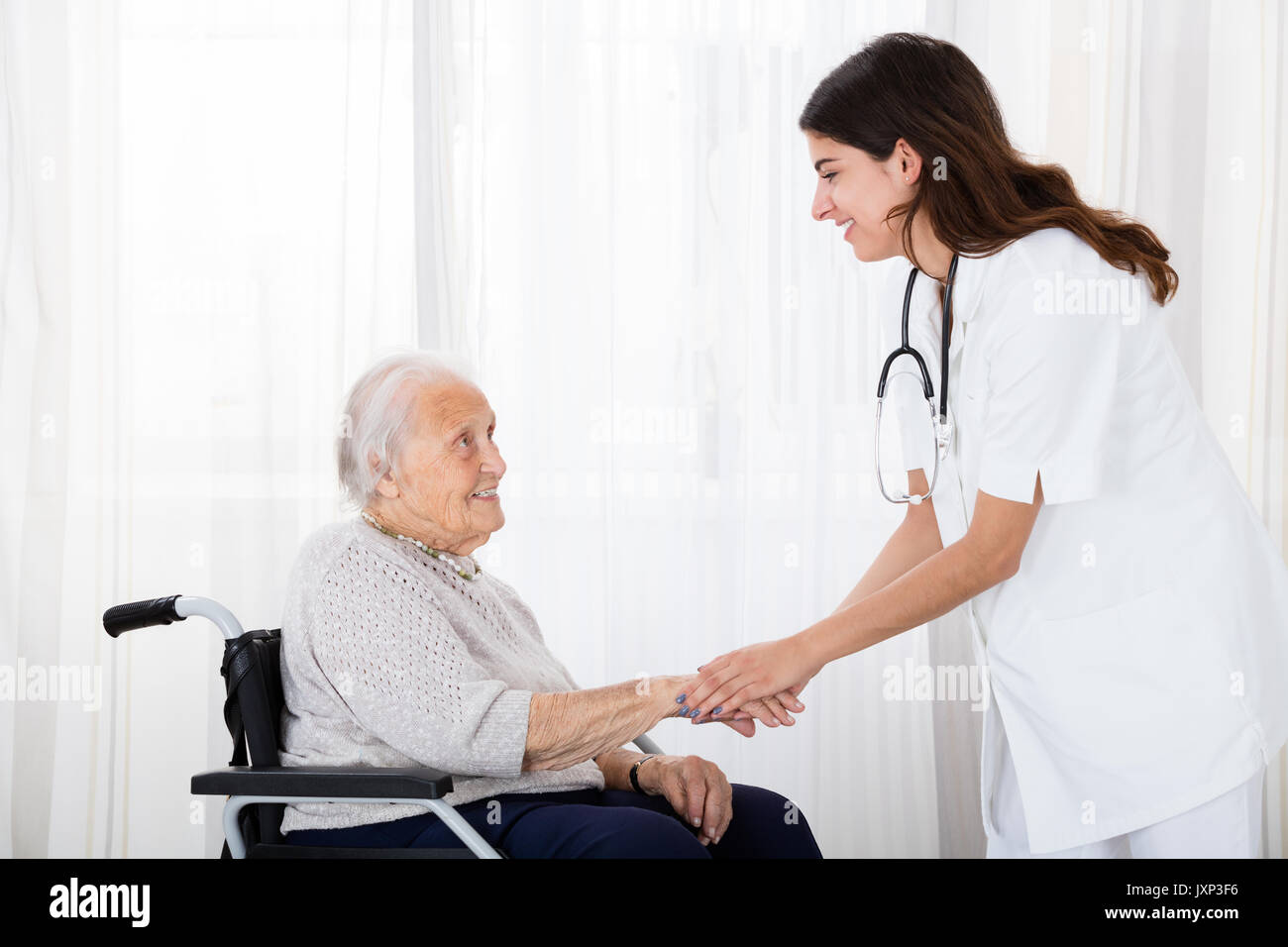 Ärztin trostreiche Deaktiviert älterer Patienten im Rollstuhl im Krankenhaus Stockfoto Ärztin trostreiche Deaktiviert älterer Patienten im Rollstuhl im Krankenhaus Stockfoto