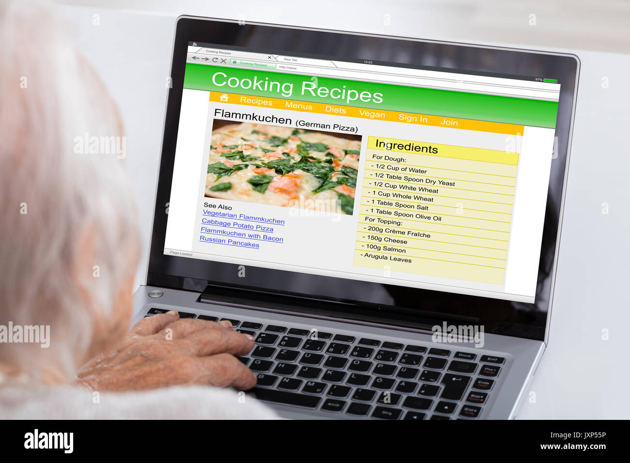 Nahaufnahme der älteren Frau mit Laptop für das Lernen Rezept auf der Website zu Hause Stockfoto