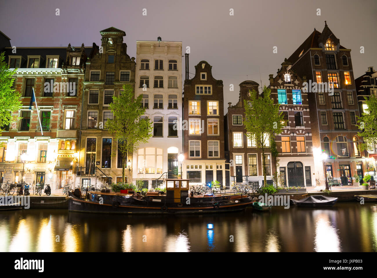 Kanäle von Amsterdam in der Nacht. Amsterdam ist die Hauptstadt und die bevölkerungsreichste Stadt der Niederlande. Stockfoto