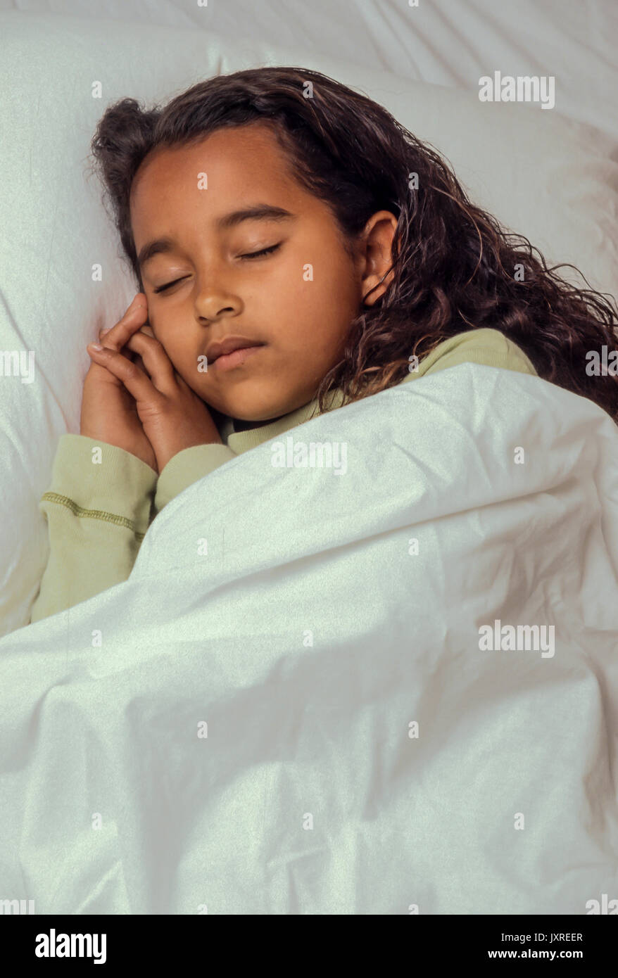Bedtime für junge Mädchen 7-10 Jahre alten schlafend im Bett friedlichen afrikanischen amerikanischen/Kaukasisch Stockfoto