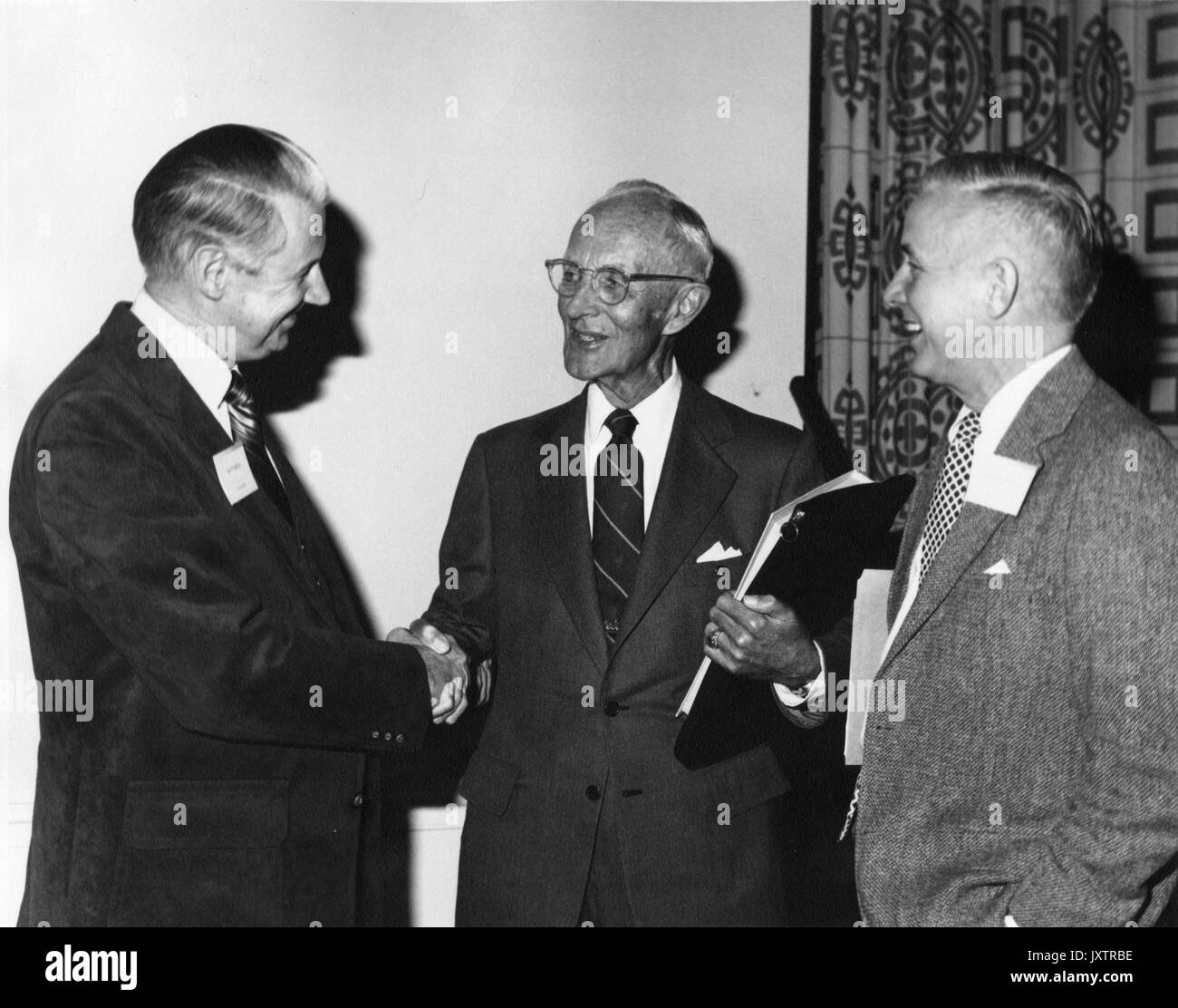 Alonzo Decker, Hays Watkins, Robert Harvery, Kampagne für Johns Hopkins Candid Gruppenbild am Greenbrier, Decker in der Mitte die Hände schütteln mit Watkins, Harvey ist rechts von Decker, 1983. Stockfoto