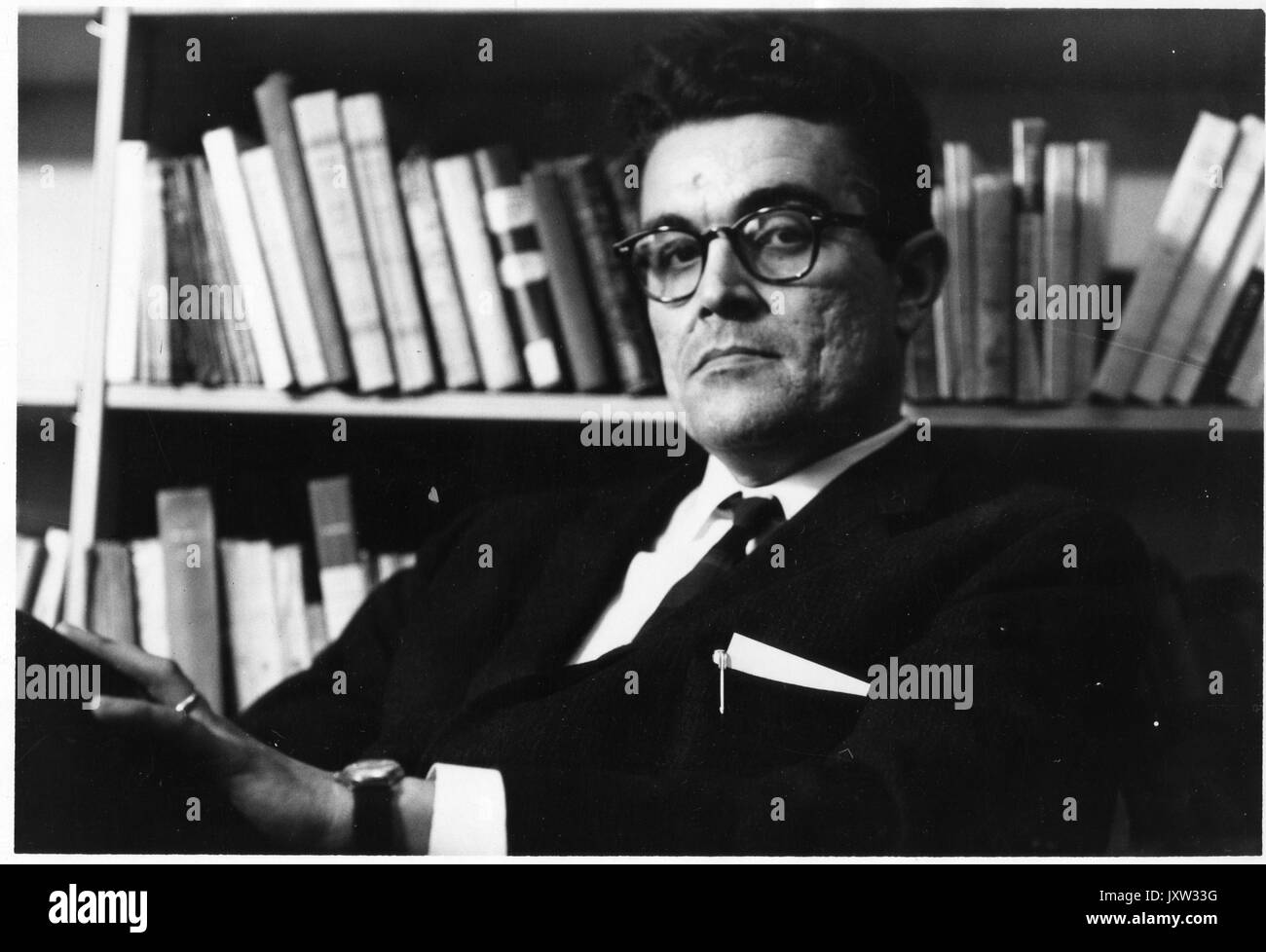 Noel Rene Girard, ehrliche Fotografie, vor Bücherregale, 1963 sitzen. Stockfoto