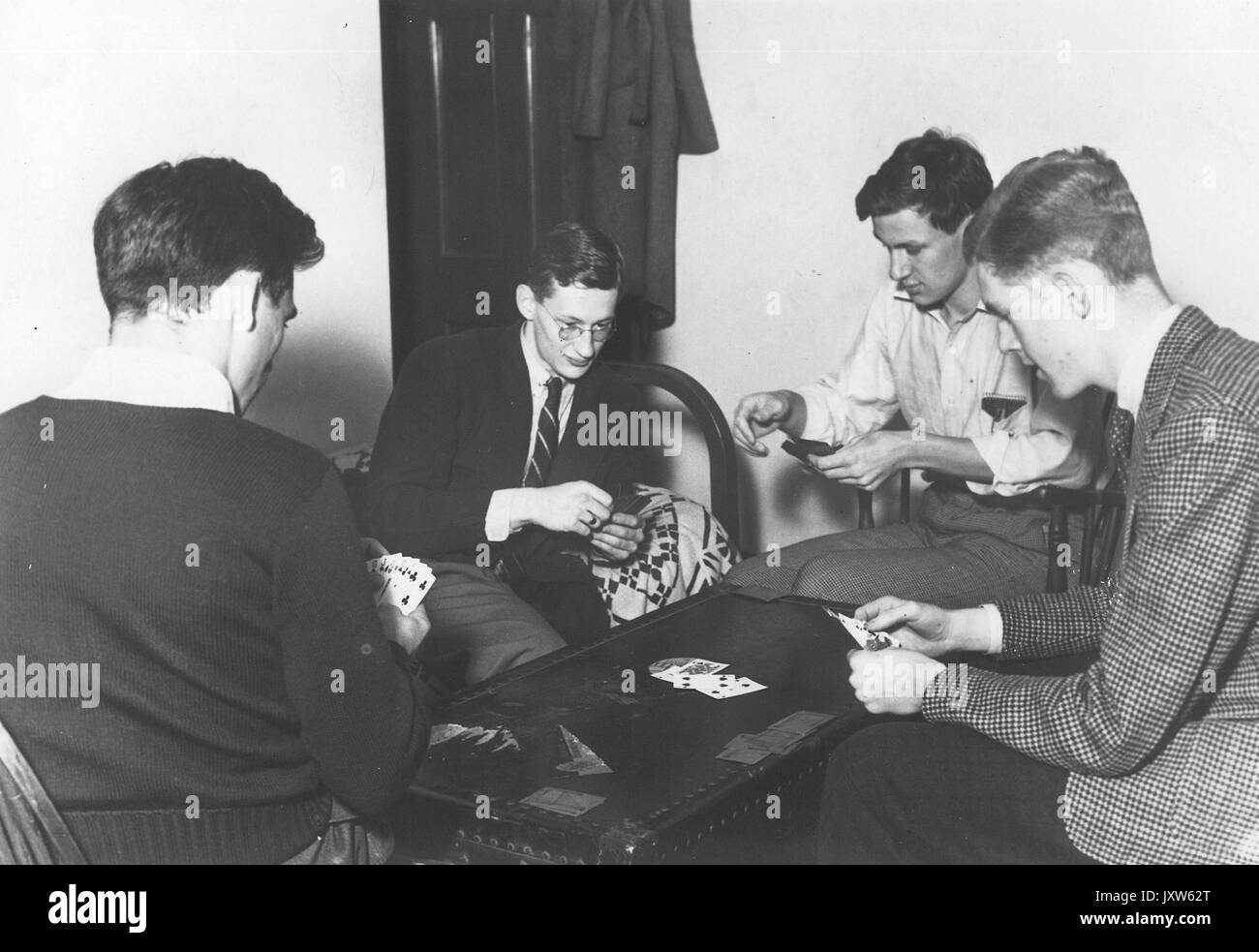 Studentenleben, Gruppe von Studenten, die ein Kartenspiel an einem Tisch in ihrem Schlafsaal spielen, 1941. Stockfoto