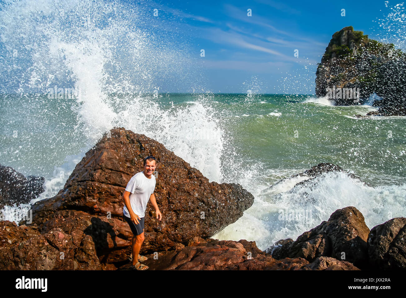 Man Flucht eingehende große Welle an der Küste in Thailand Stockfoto