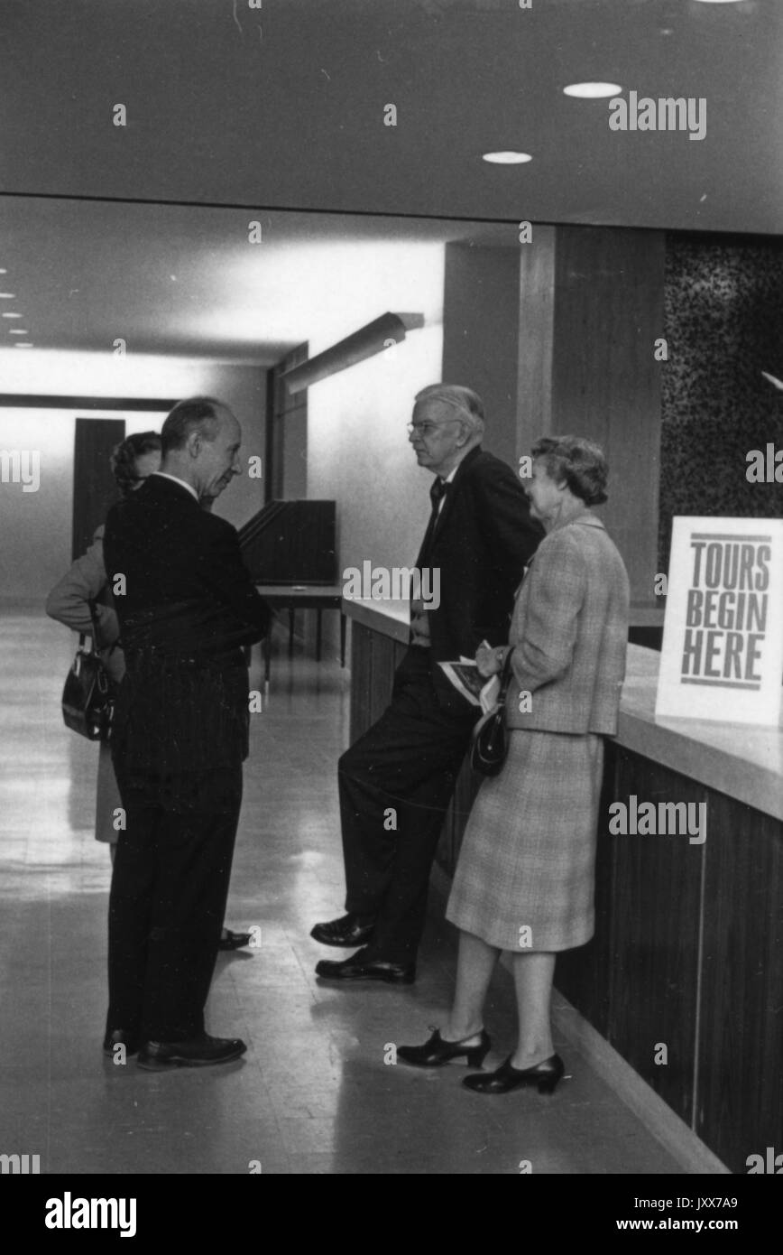 Eine Gruppe von Menschen stehen auf m-Ebene des mse Bibliothek mit einem Schild Rundgänge beginnen hier, 1964. Stockfoto