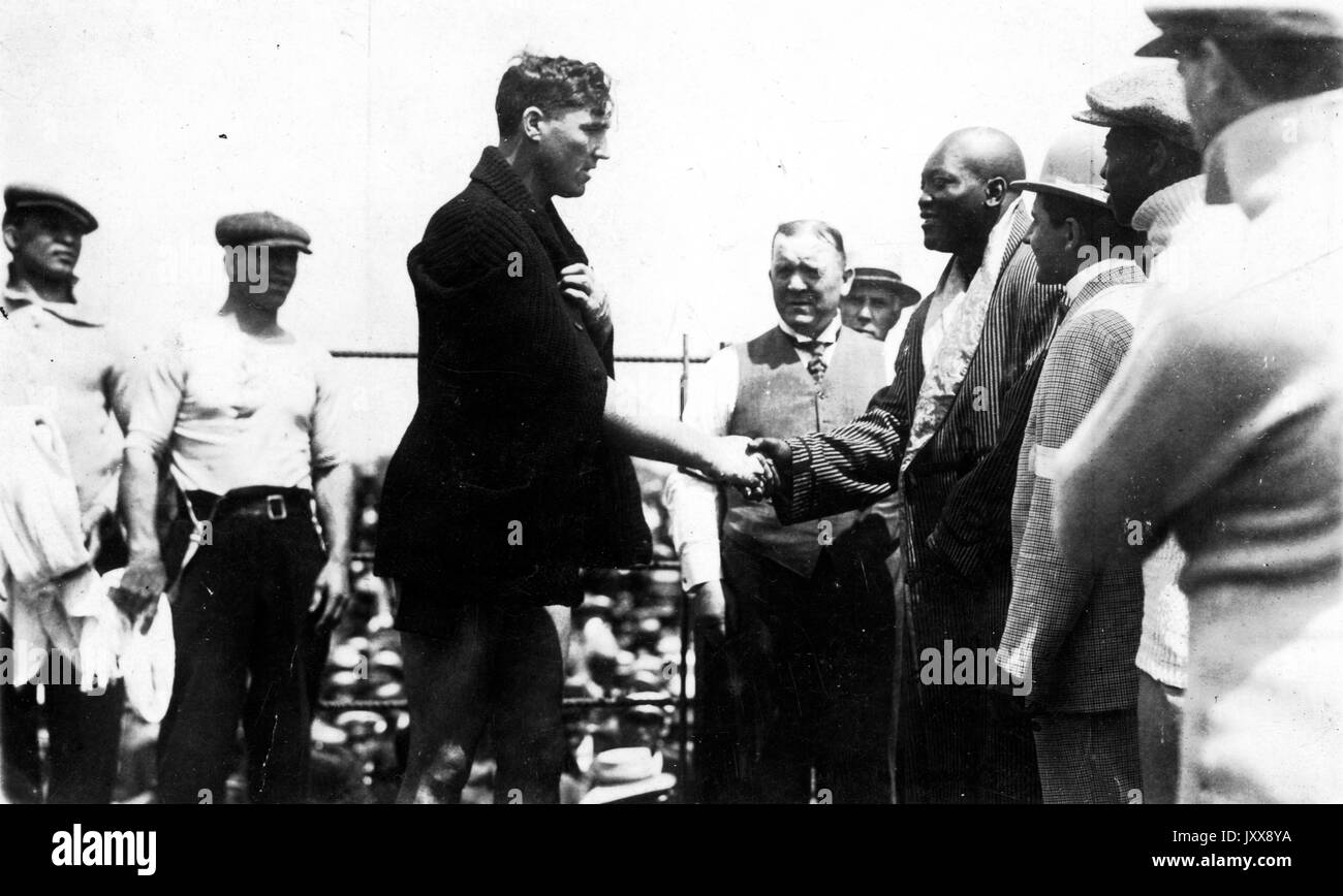 Die Boxer Jack Johnson (Mitte links) und Jess Willard (Mitte rechts), umgeben von anderen Branchenmitgliedern, schütteln vor ihrem berühmten Kampf beim 26. Lauf der Schwergewichtsboxmeisterschaft auf der Oriental Park Racetrack in Havanna, Kuba, am 5. April 1915 die Hände. Stockfoto