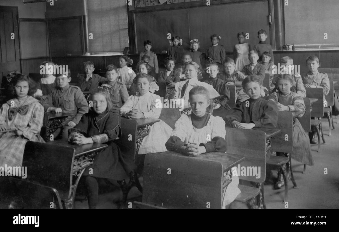 Volle Länge Landschaft schoss der Schulkinder am Schreibtisch sitzt, Afrikanische amerikanische Studenten in den Rücken, 1920. Stockfoto