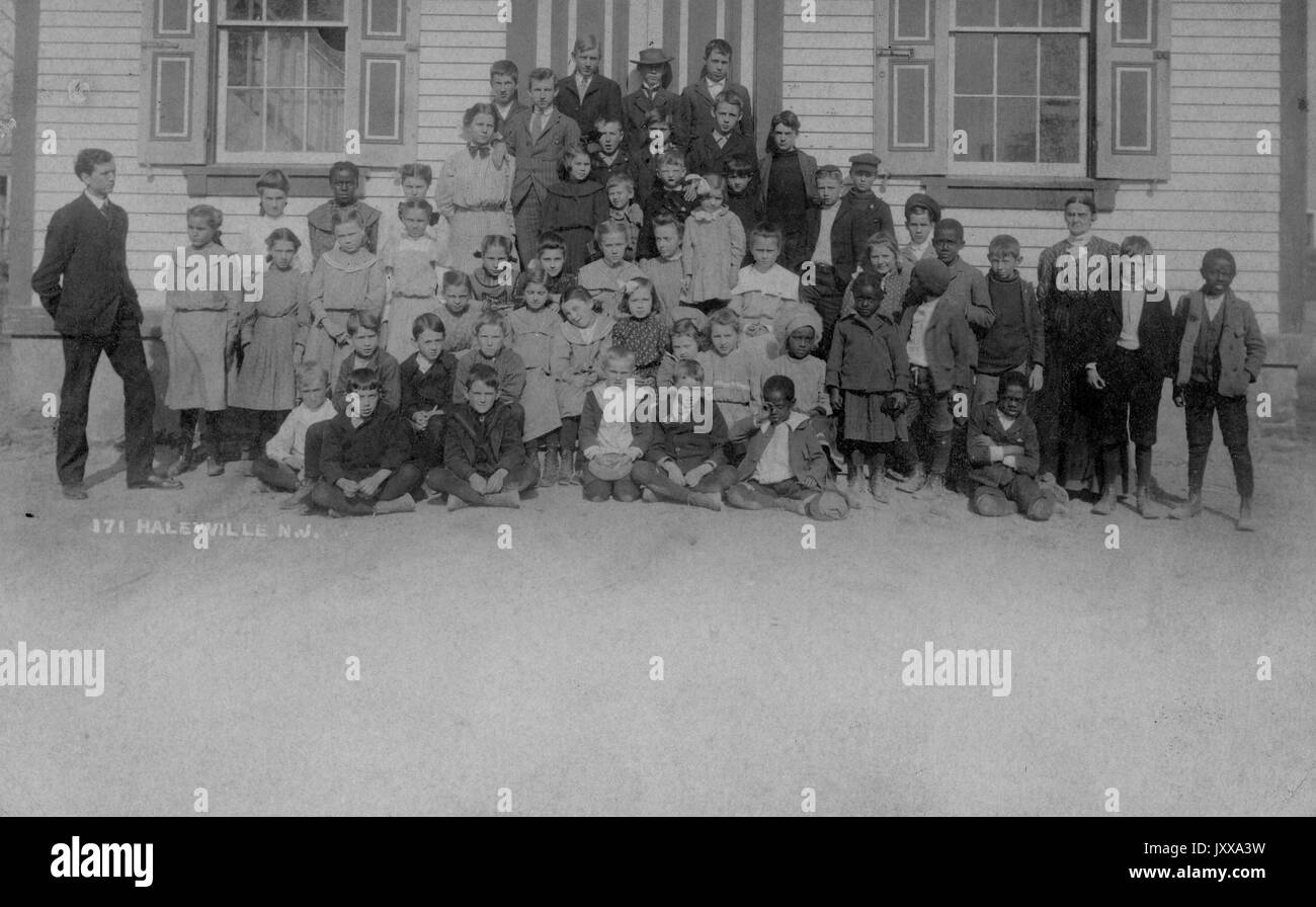 Ganzkörperaufnahme von Schulkindern, einige sitzend, einige stehend, einige afroamerikanisch, im Freien; Haleyville, New Jersey, 1915. Stockfoto