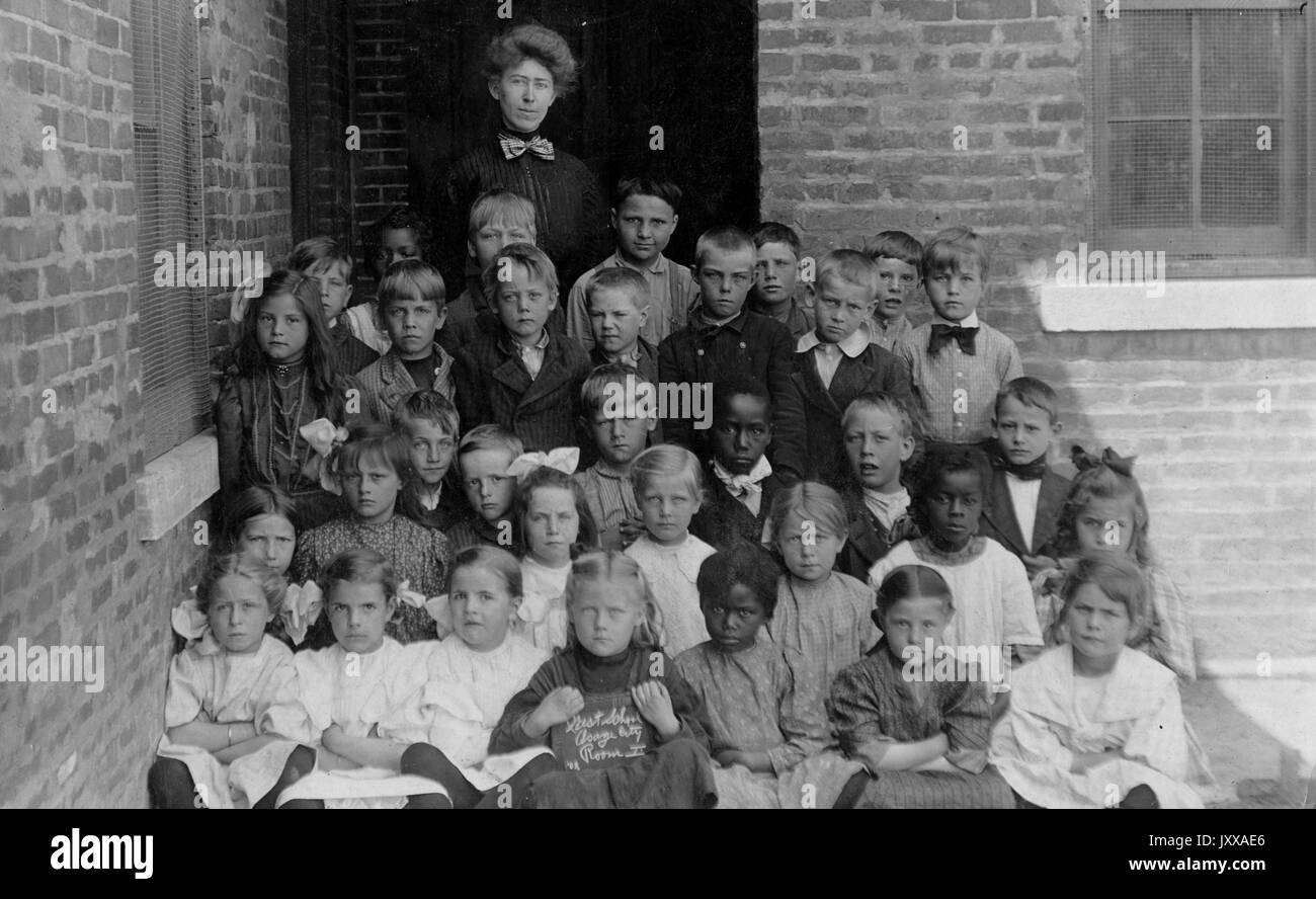 Ganzkörperaufnahme von Schulkindern, alle mit einer Lehrerin, afroamerikanische Studenten integriert, 1920. Stockfoto