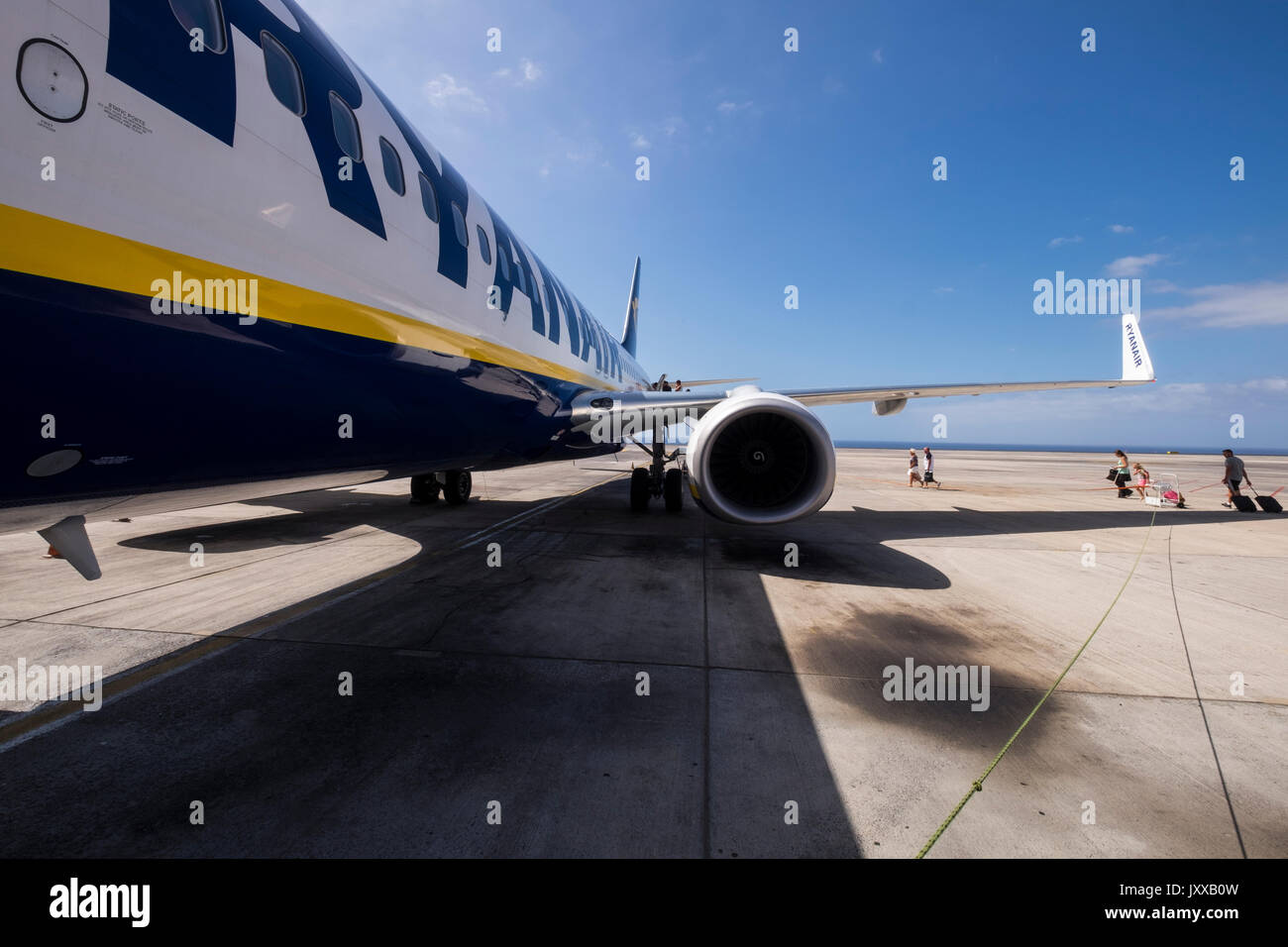 Ryanair Flugzeug auf der Rollbahn mit Passagieren zu Fuß zu der hinteren Tür, Reina Sofia Flughafen, Teneriffa, Kanarische Inseln, Spanien Stockfoto