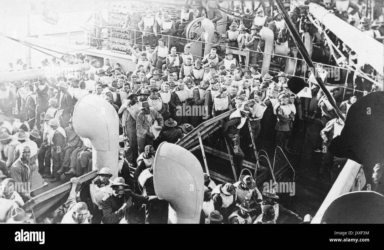 Viele afroamerikanische und weiße Soldaten sind an Bord eines Marineschiffes, die meisten tragen helle Sicherheitswesten, 1920. Stockfoto