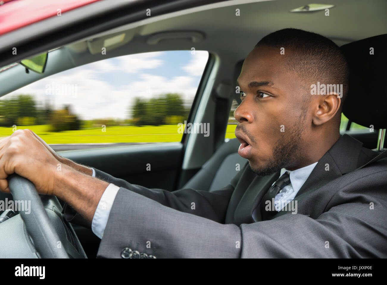 Junge Unternehmer mit offenem Mund Auto Schockiert Stockfoto