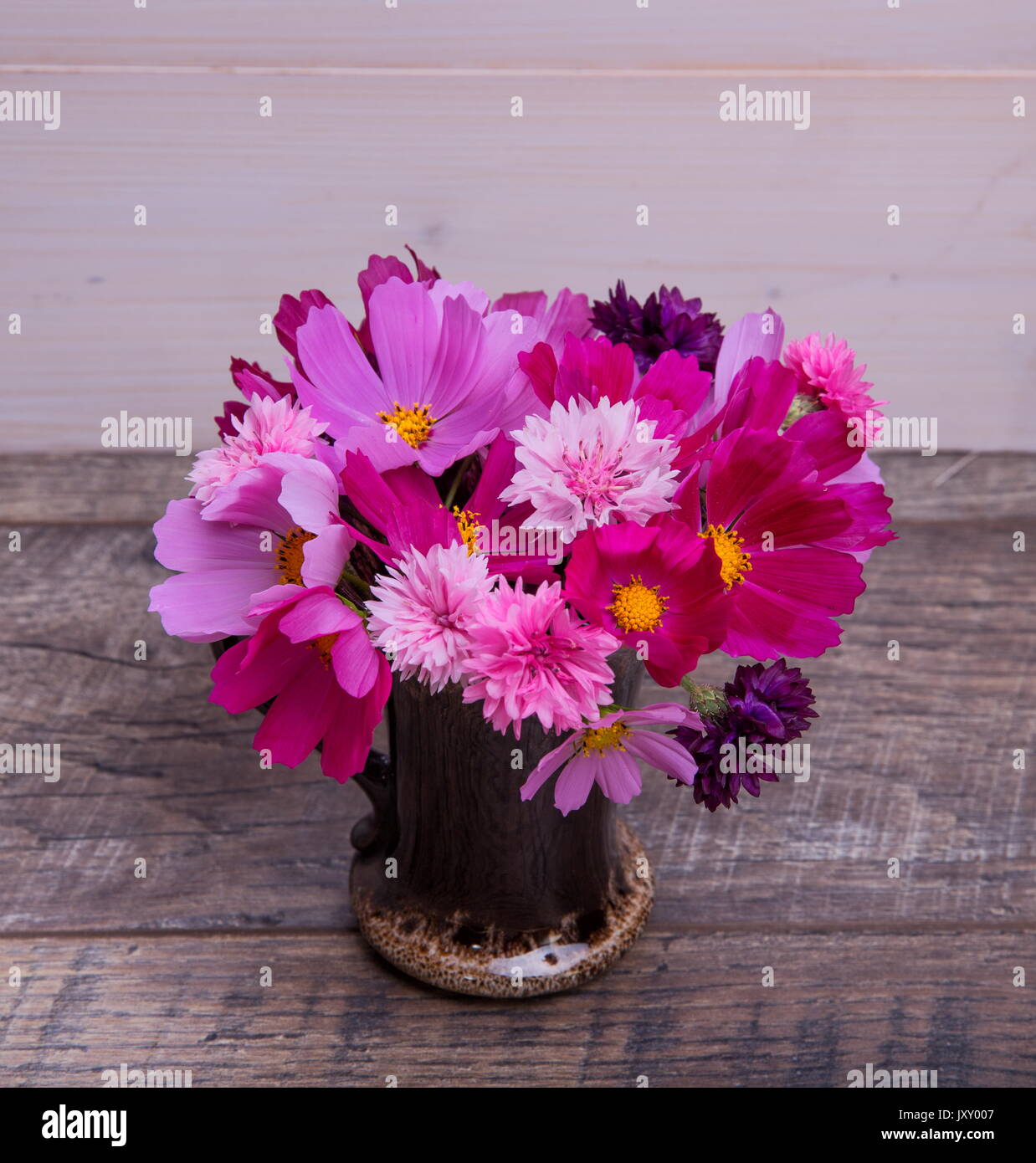 Ein Bouquet von rosa und lila Blumen cosmea oder Cosmos mit Band auf rustikalen hölzernen Brettern. Kopieren Sie Platz. Mutter, Valentines, Frauen, Hochzeit Konzept Stockfoto
