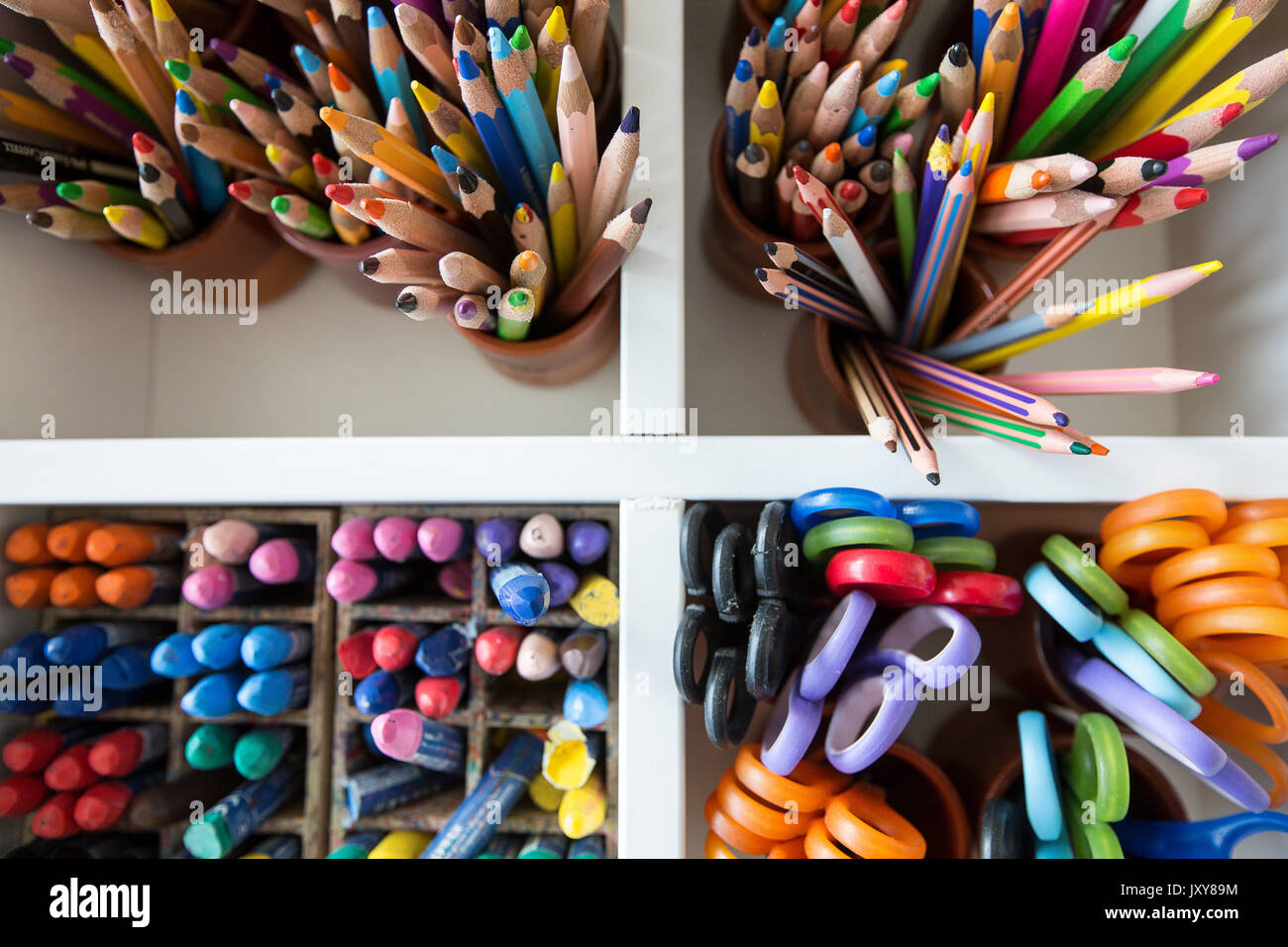 Grundschule, Grundschule oder Kindergarten. Buntstifte, Pastell und Schere in einem weißen Möbel Stockfoto