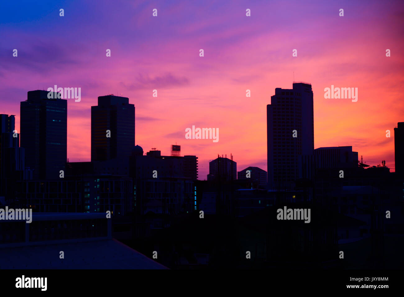 Die Silhouette der Stadt mit der Dämmerung und schönen Himmel. schöner Moment mit bunten Himmel auf Stadt. Gebäude mit bunten Himmel am Morgen. die Stadt Bangkok und bunten Stockfoto