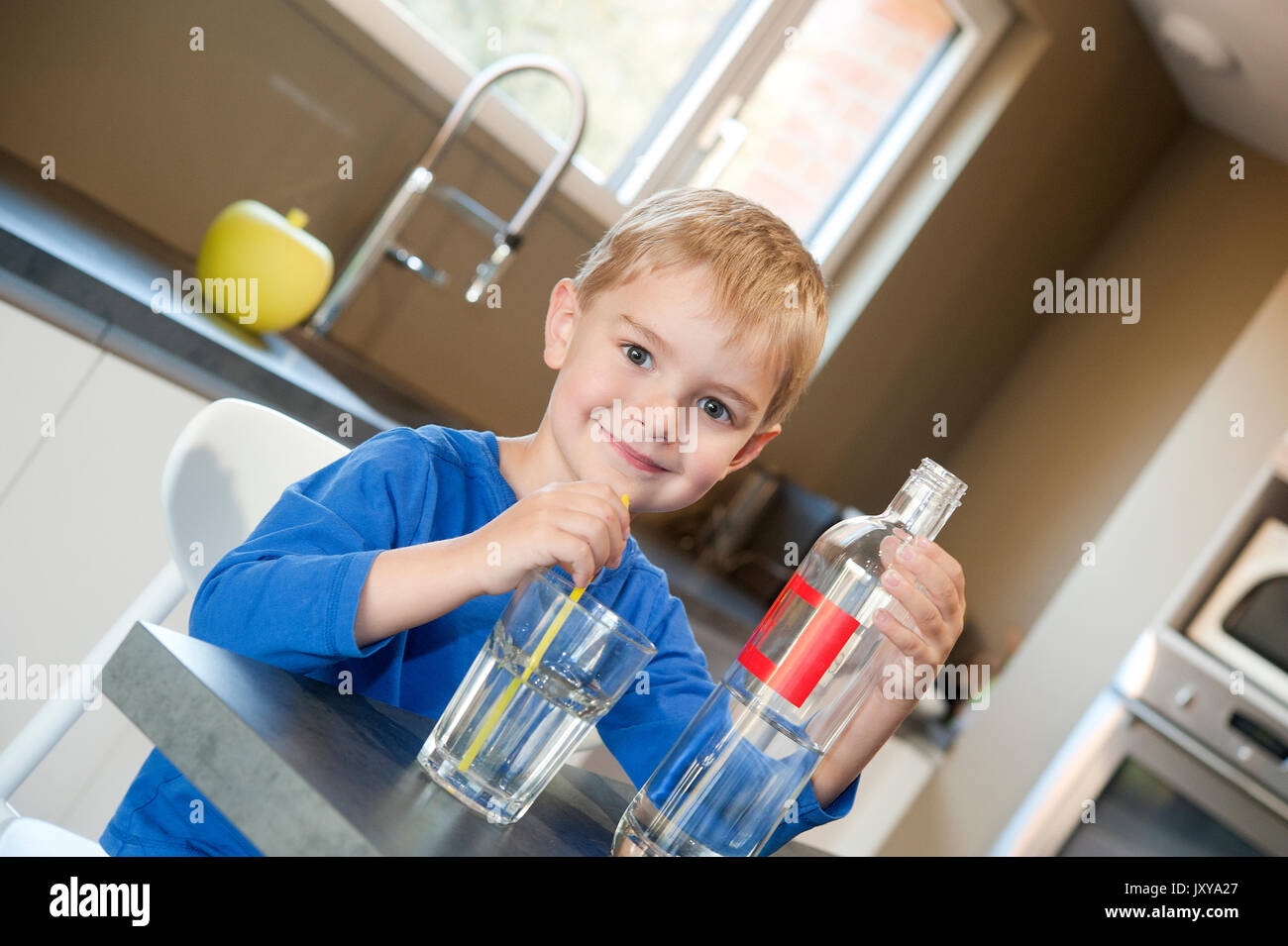 5-jähriger Junge Trinkwasser durch einen Strohhalm Stockfoto