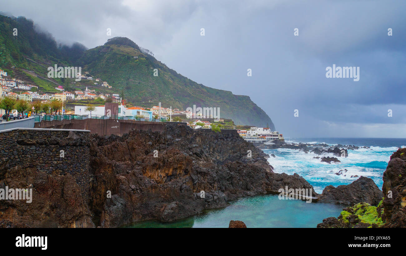 Madeira - Küste Stadt Porto Moniz mit groben Blue Ocean und regnerischen Wolken Stockfoto