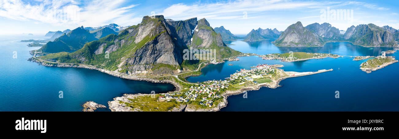 Antenne Panoramablick auf Reine traditionelle Fischerdorf in der Lofoten Inseln im nördlichen Norwegen mit blauem Meer und Berge während der sonnigen arcti Stockfoto