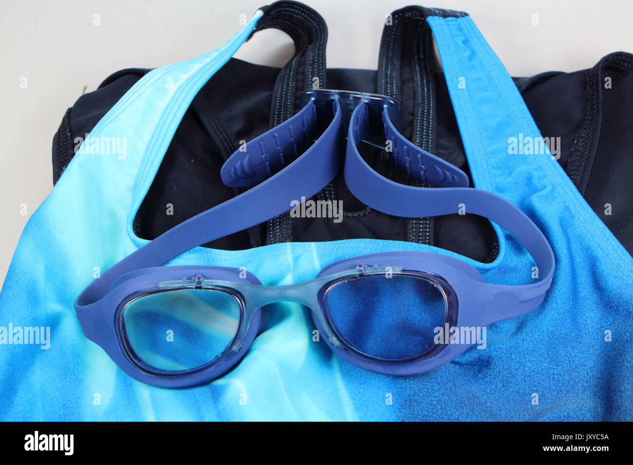 Blue Schwimmbrille über einem blauen Badeanzug Stockfoto