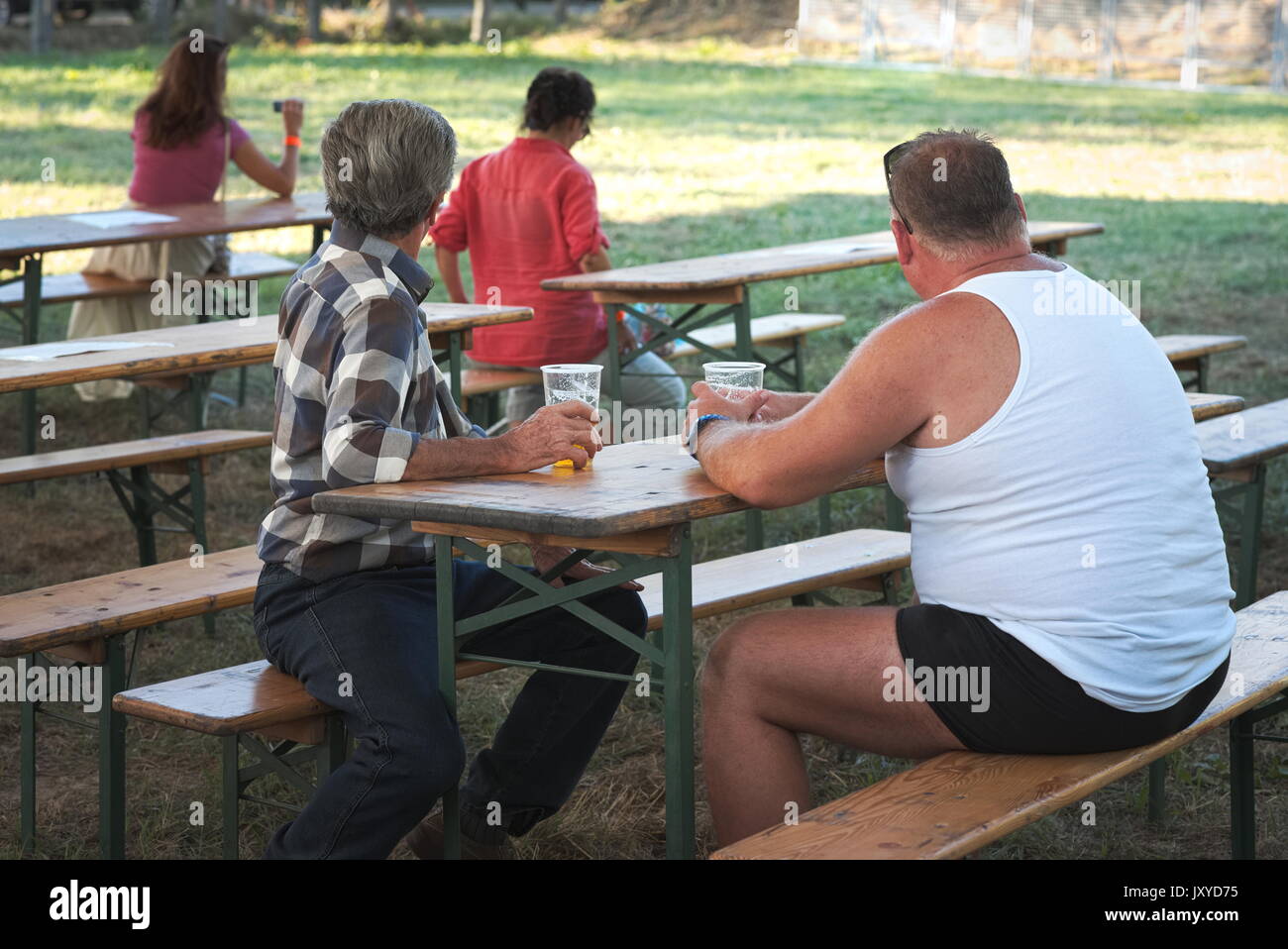 Zwei Männer sitzt auf der Bank am Festival Bier trinken. Stockfoto