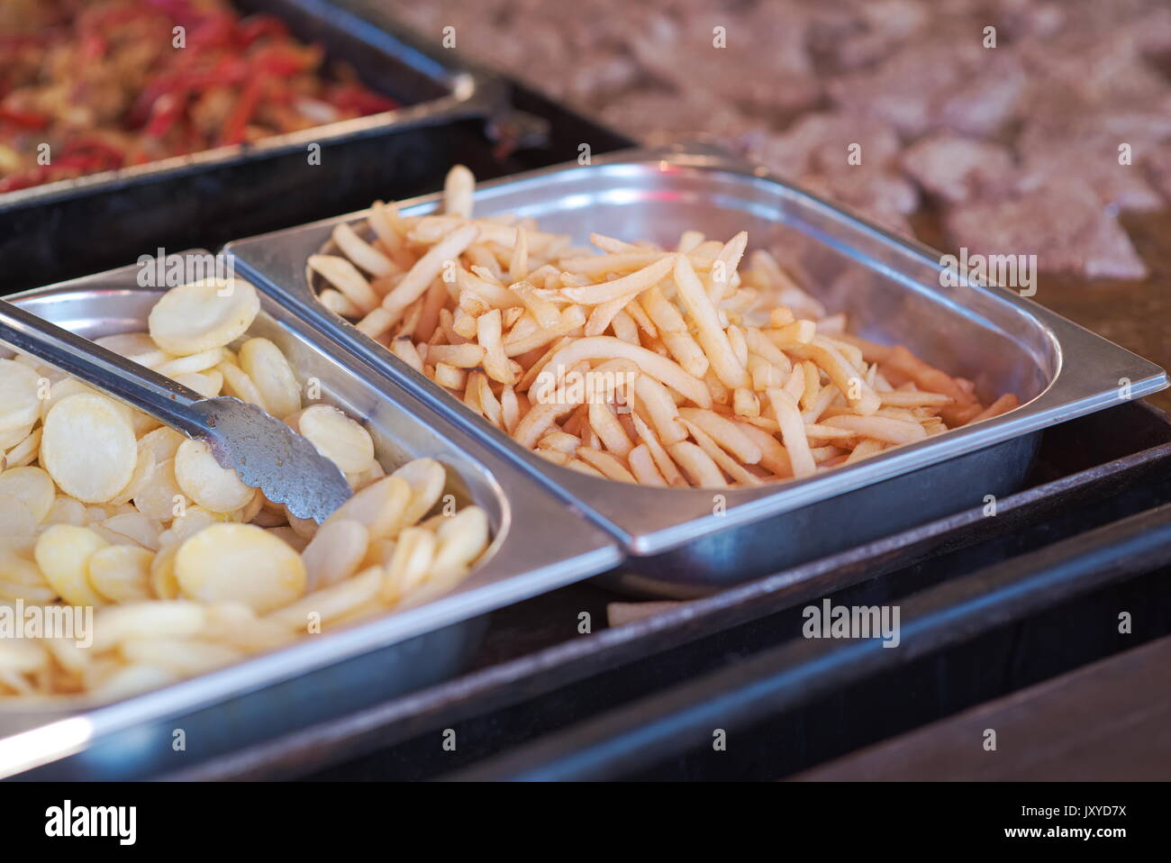 Pommes Frites und Kartoffelchips auf einem Fast Food Stand Stockfoto