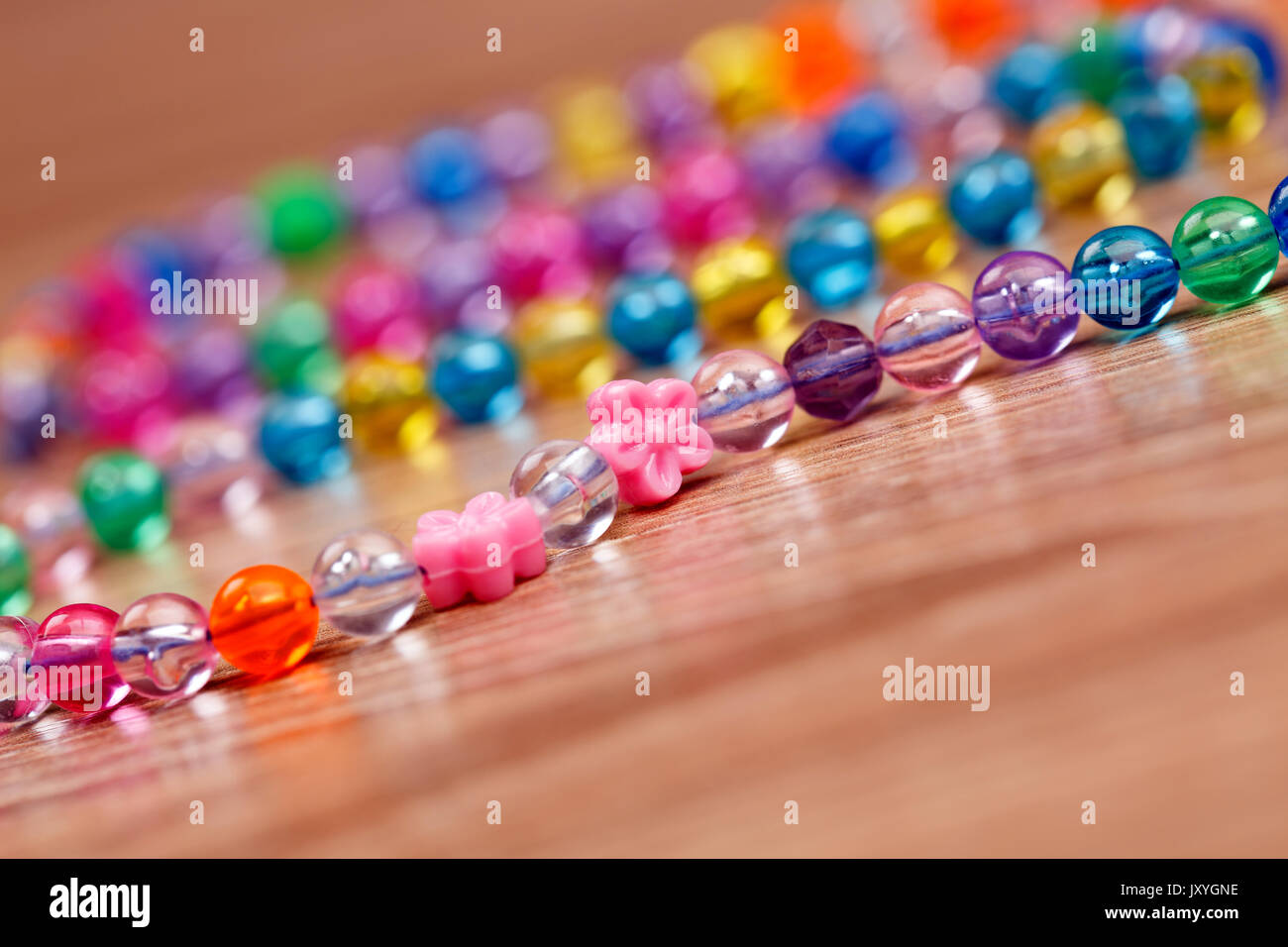 Dekoration von Glasperlen auf einem hölzernen Hintergrund liegen. Makroaufnahme. Stockfoto