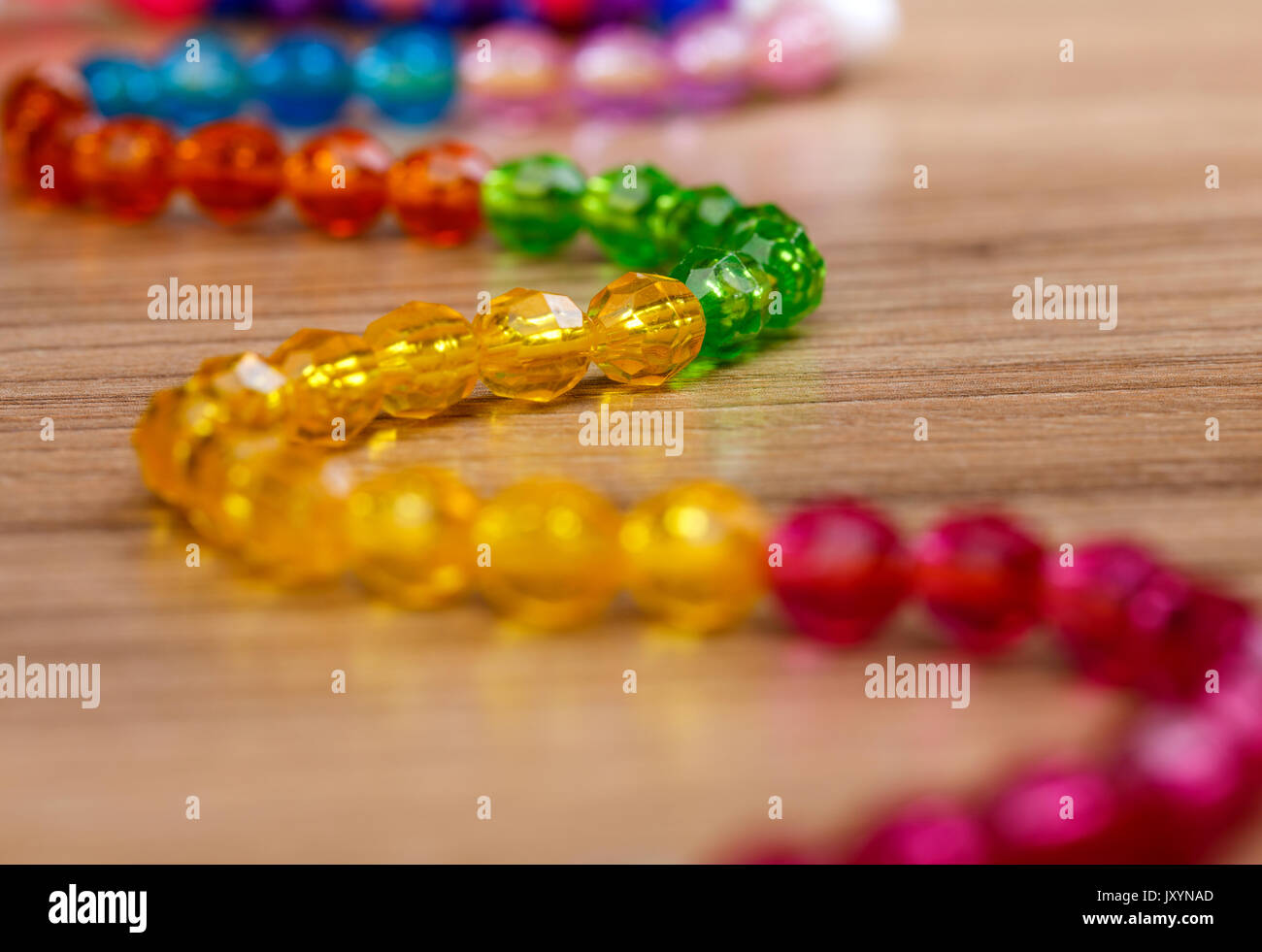 Schöne Schlange aus bunten Perlen auf einer hölzernen Hintergrund Stockfoto