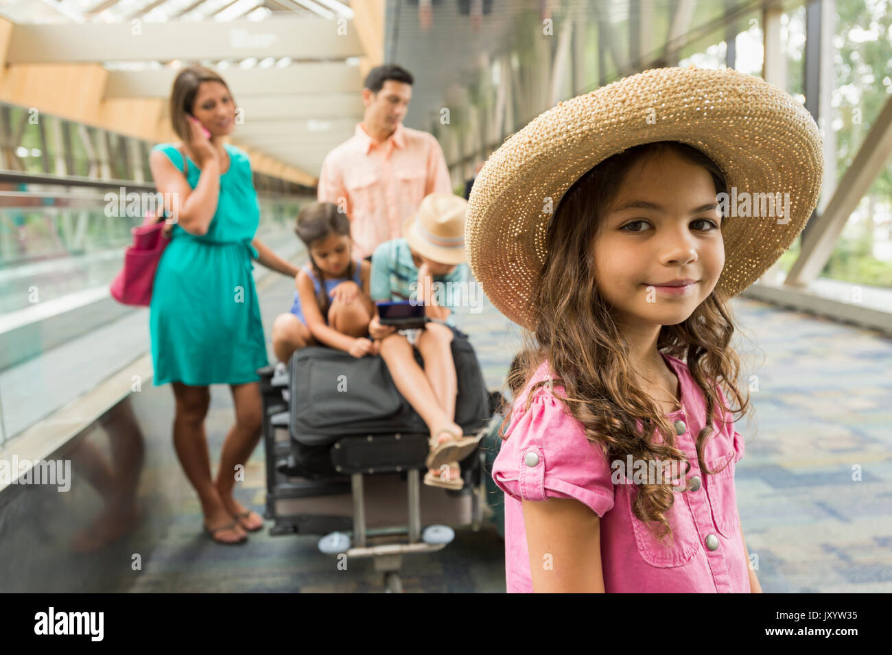 Portrait von Mädchen Warten im Flughafen mit Familie Stockfoto