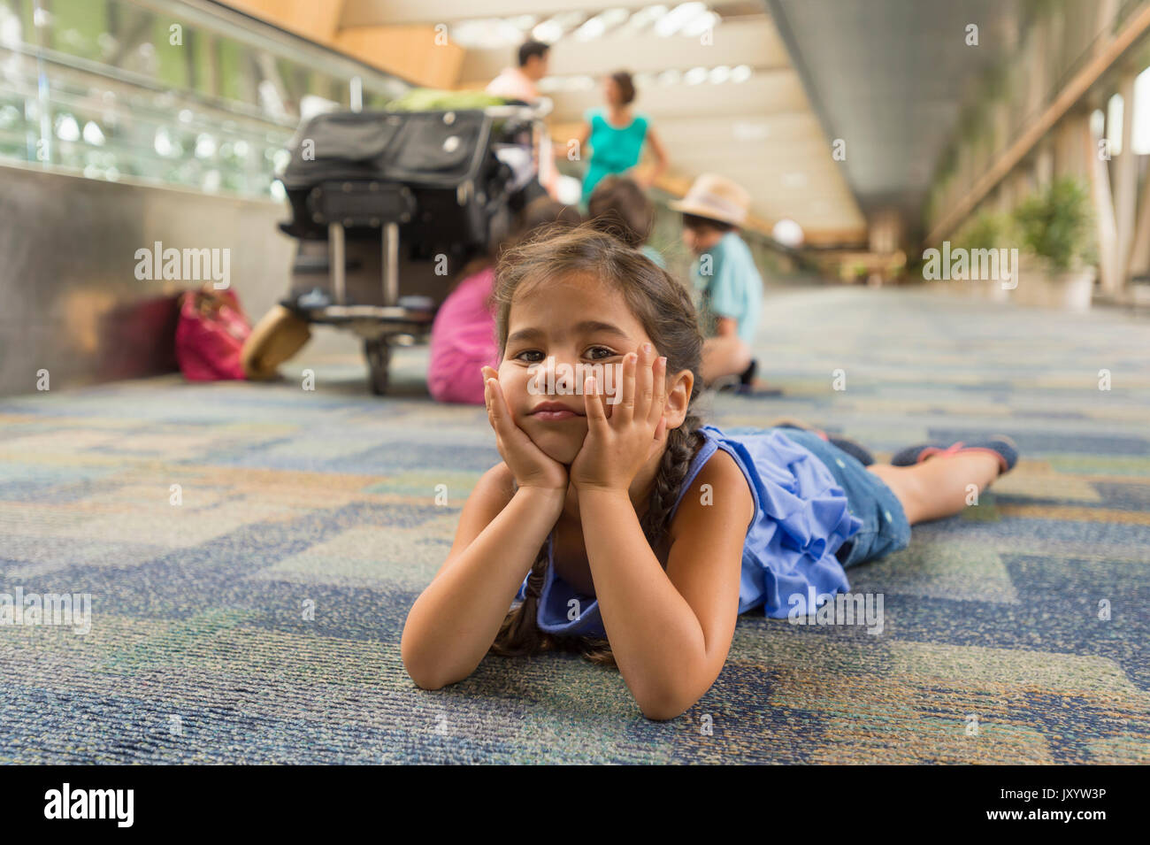 Gelangweilt Mädchen mit auf dem Boden der Flughafen Stockfoto