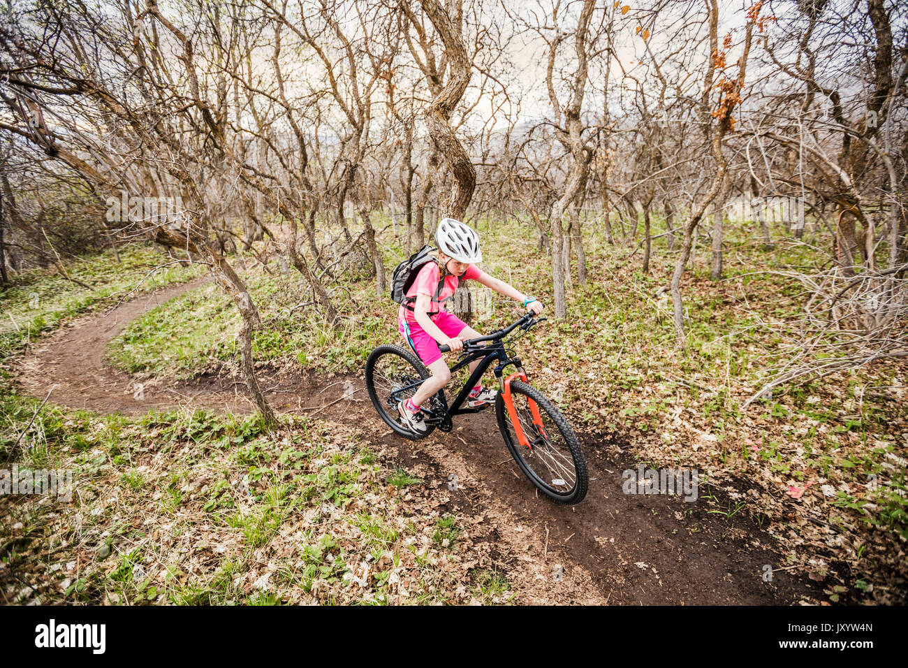 Kaukasische Mädchen reiten Fahrrad auf Waldweg Stockfoto