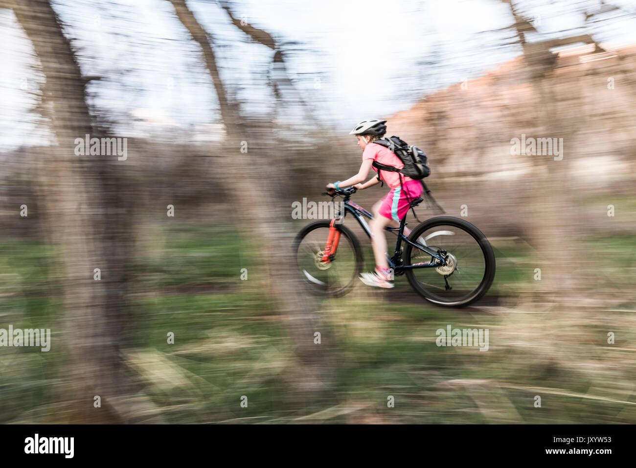 Kaukasische Mädchen reiten Fahrrad auf Waldweg Stockfoto