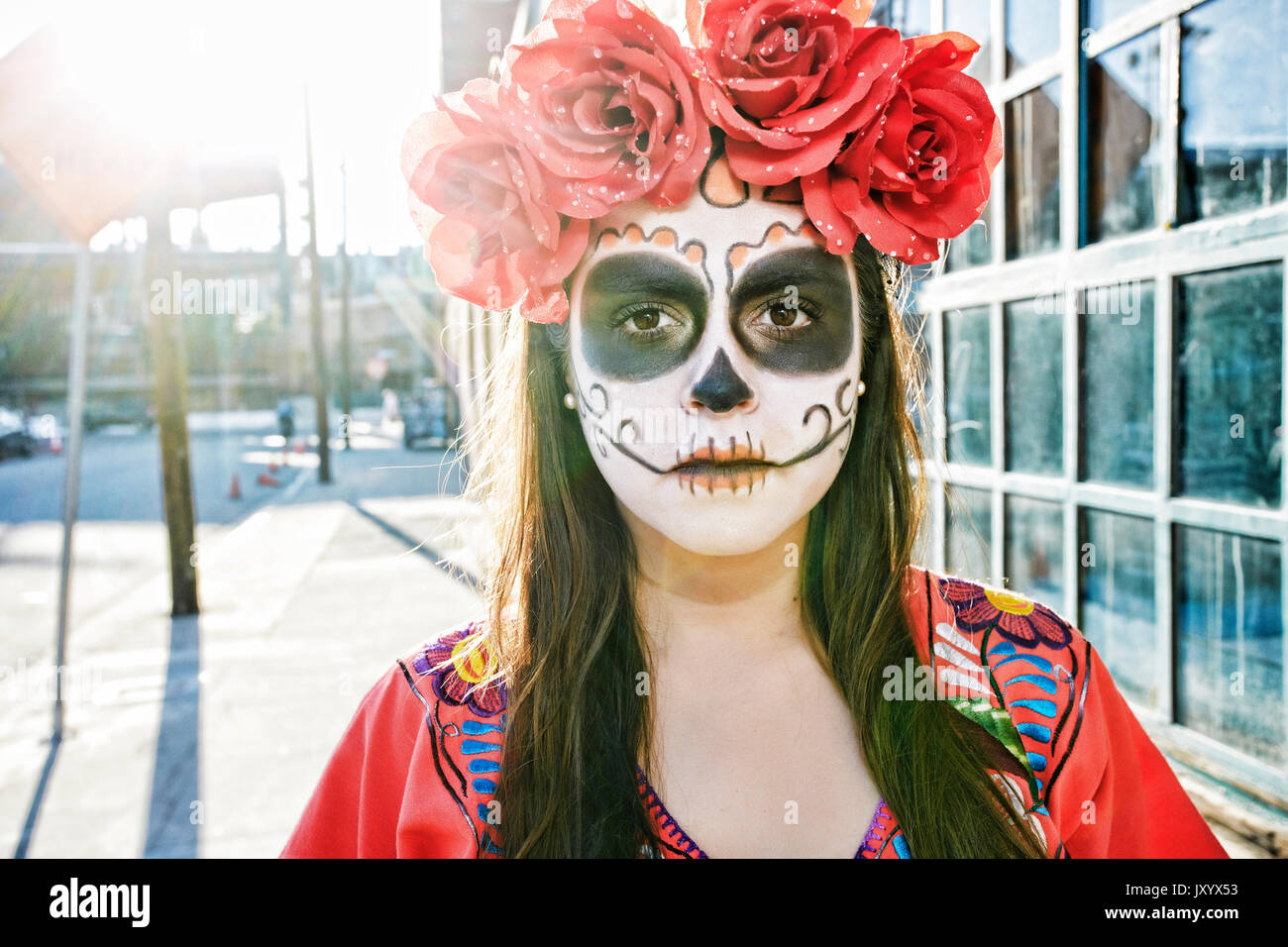Hispanic Frau auf dem Bürgersteig tragen Schädel Gesicht Farbe Stockfoto