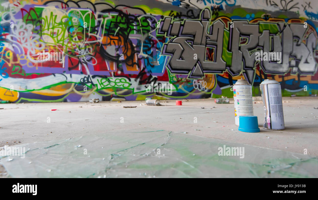 Sprühen Sie in einem verlassenen Geschäftsgebäude in Sydney, Australien, bemalte und mit Graffiti gekennzeichnete Wände und Aerosoldosen Stockfoto