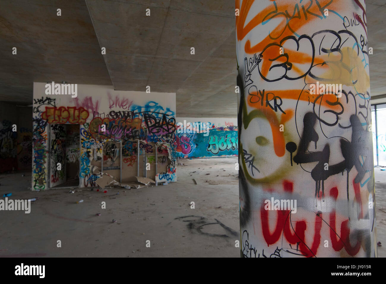 Sprühen Sie in einem verlassenen Geschäftsgebäude in Sydney, Australien, bemalte und mit Graffiti gekennzeichnete Wände und Aerosoldosen Stockfoto