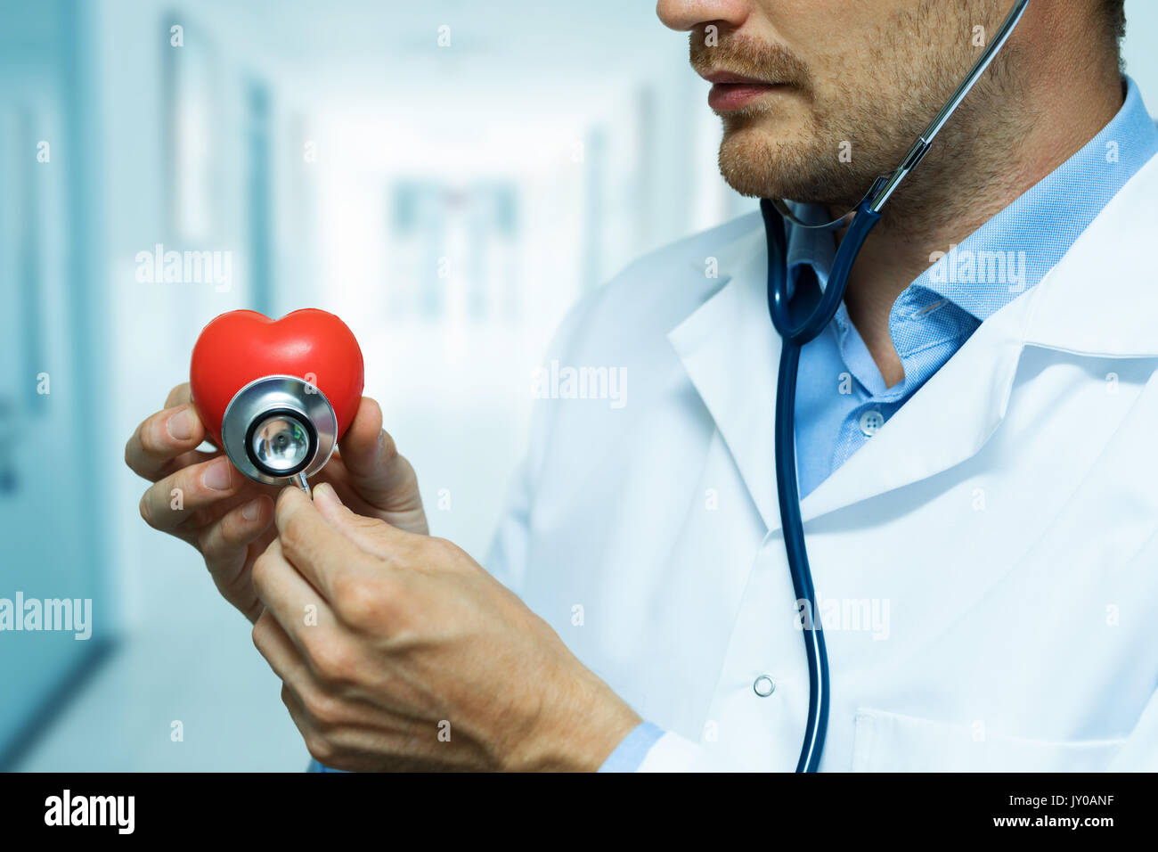 Kardiologe Kontrolle rotes Herz mit Stethoskop. Kardiologie Konzept Stockfoto