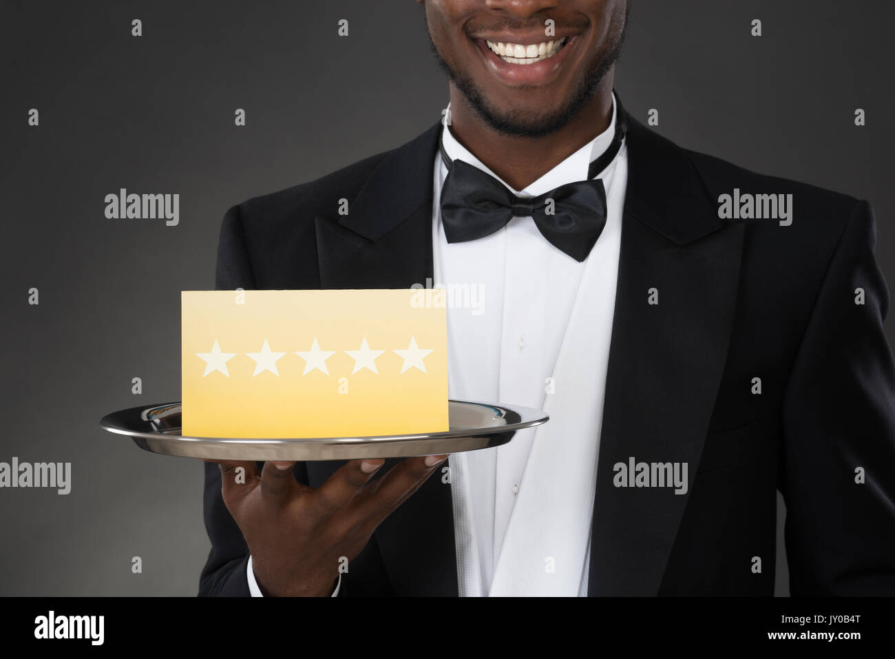 Portrait der Afrikanischen Kellner Halteplatte mit Sterne Stockfoto