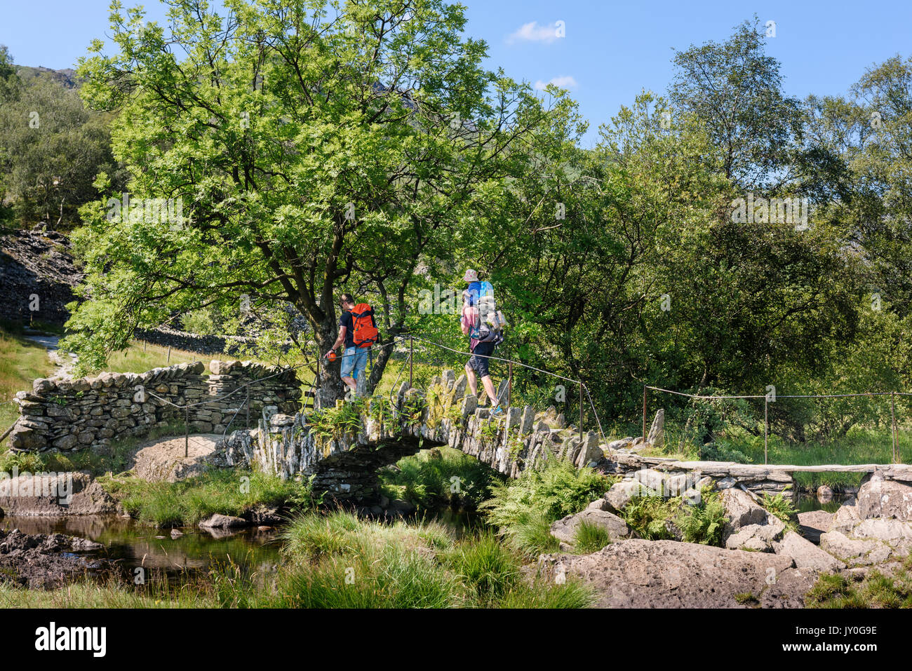 Zwei Männer, die Kinder über Slater's Bridge Little Langdale, Lake District, Cumbria Stockfoto