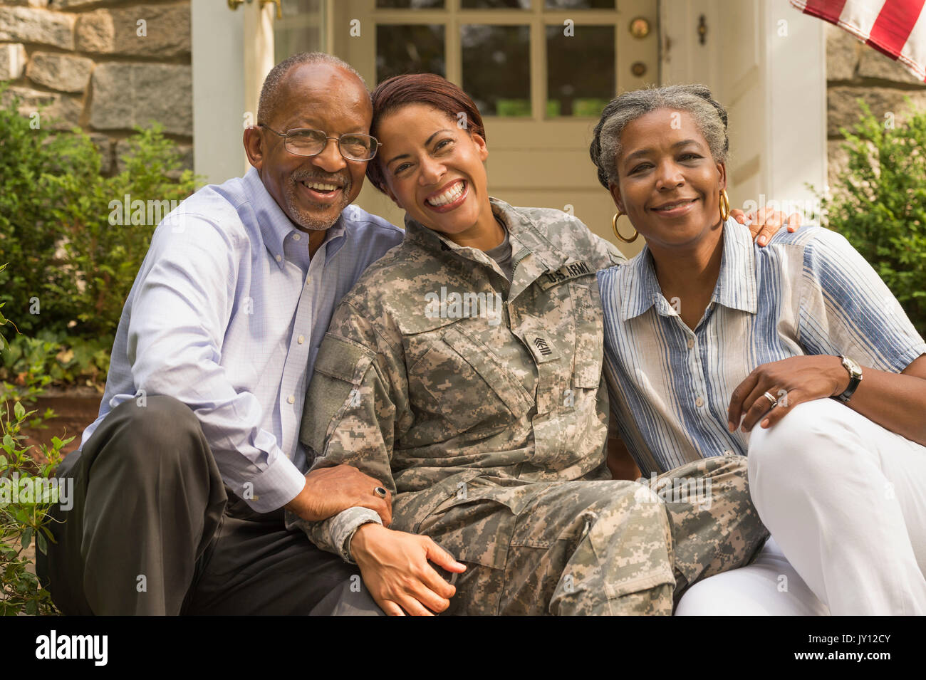 Porträt der Soldat sitzt auf der vorderen Stoop mit Eltern Stockfoto