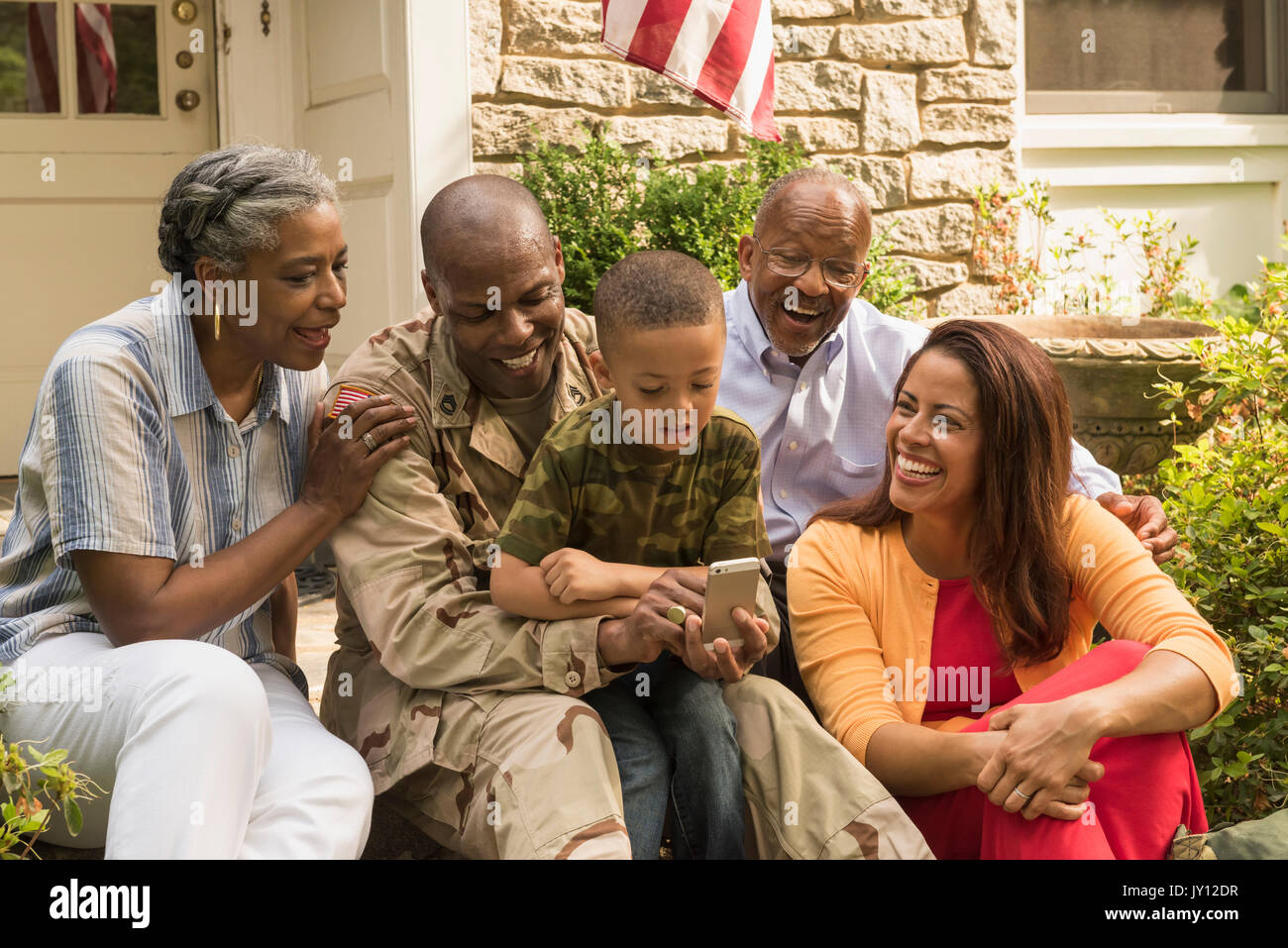 Soldat und multi-Generation, Familie, die auf dem Mobiltelefon Stockfoto