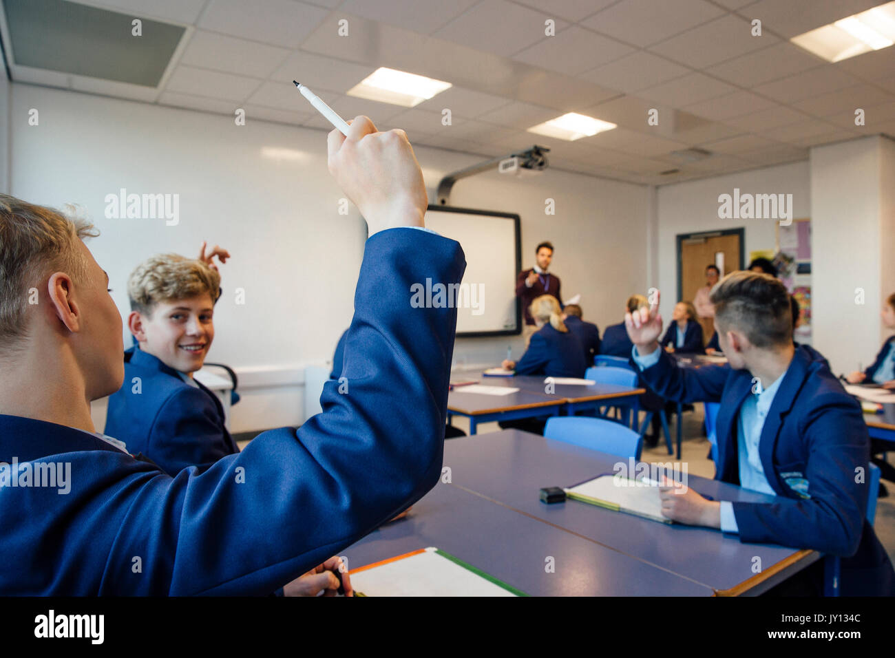Sicht der Schuß eines High School lesson, wo der Lehrer eine Frage gestellt hat und einige Studenten haben ihre Hände bis zu beantworten. Stockfoto