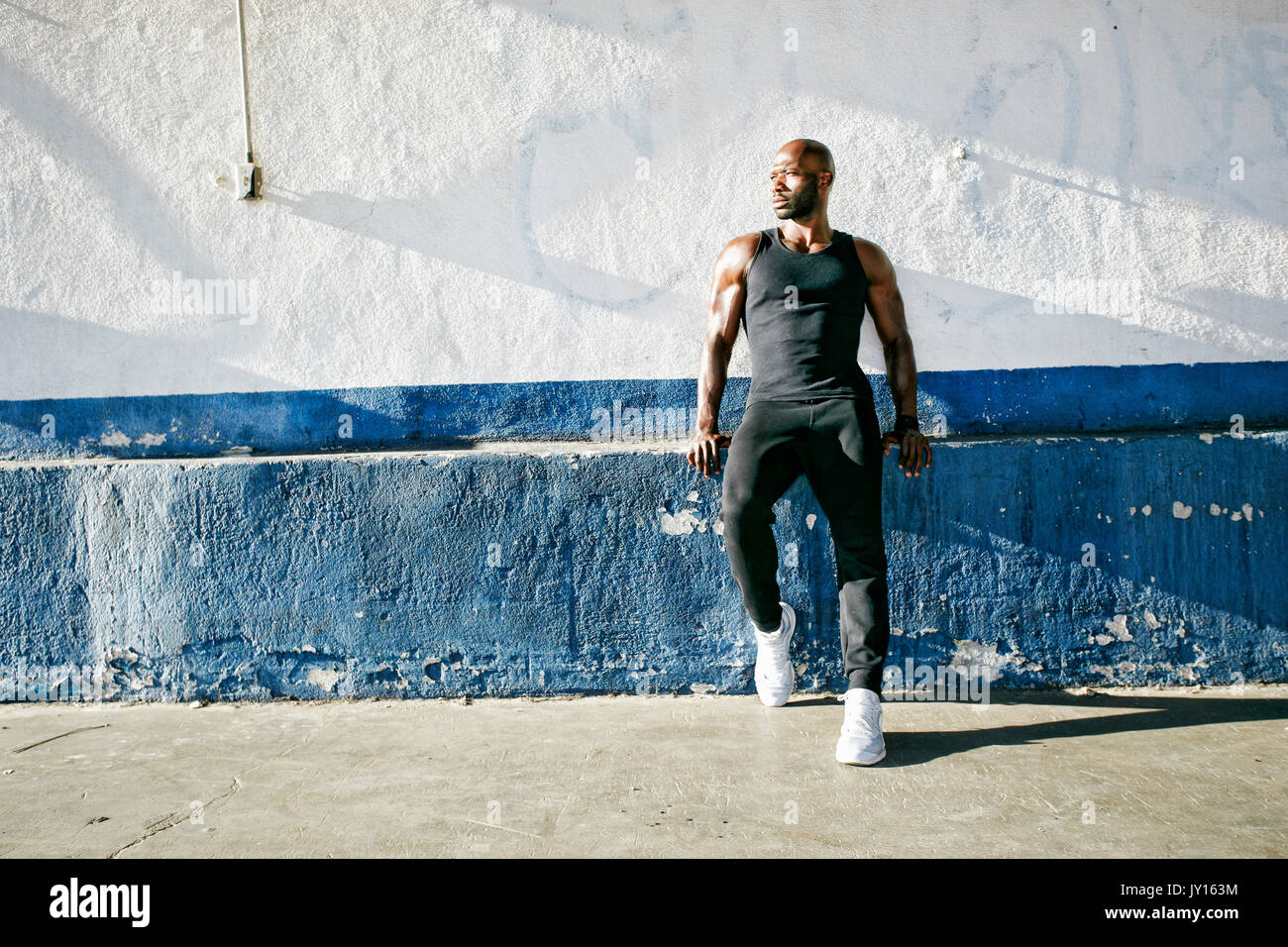 Schwarzer Mann lehnte sich auf Vorsprung der Wand Stockfoto