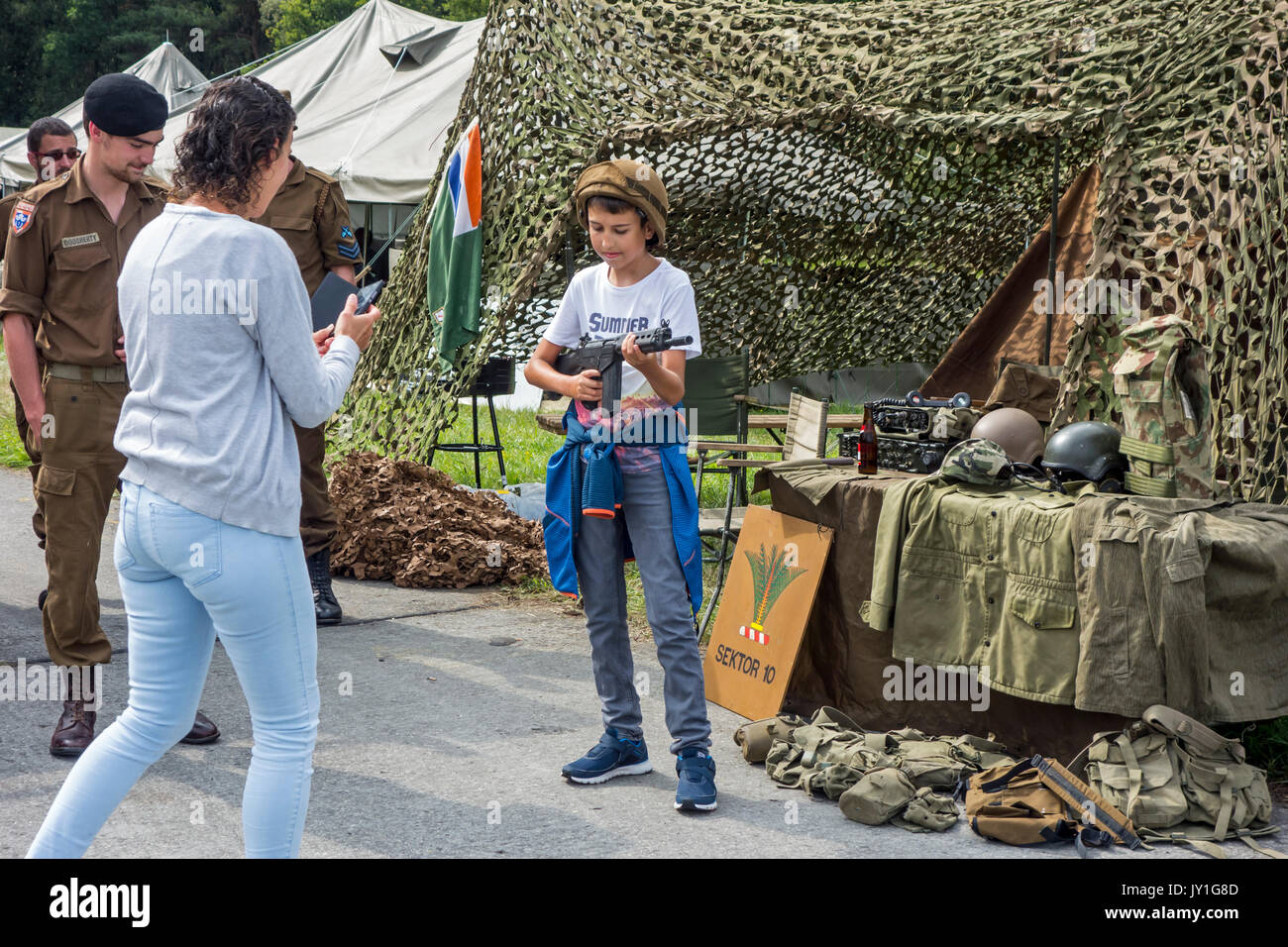 Kind posiert mit Replik von automatischen Gewehr an reenacment Camp während Militaria Messe Stockfoto