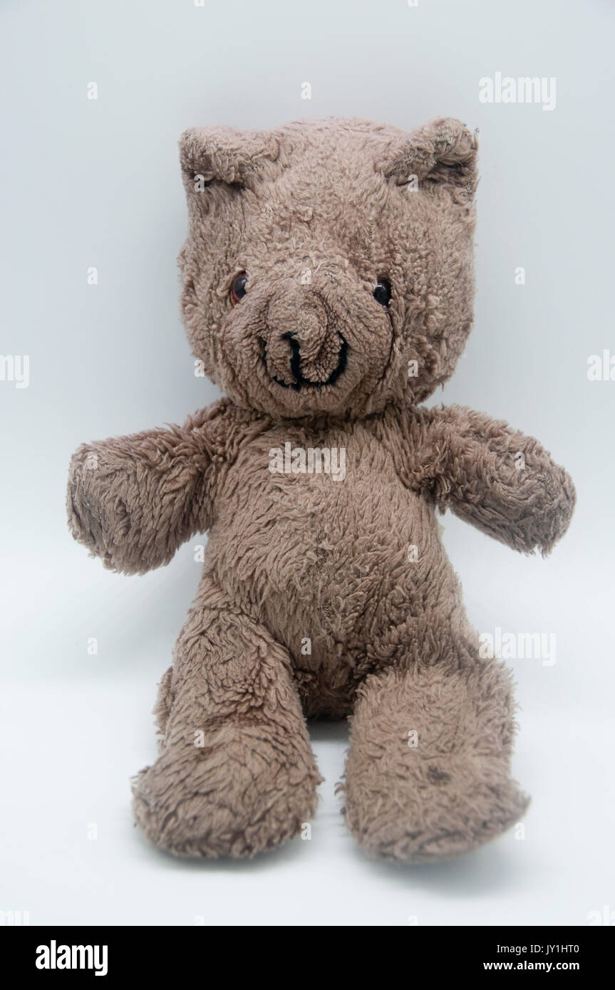 Eine einzelne, alte Teddybär in sitzender Position mit einem weißen Hintergrund, Porträt Stil. Stockfoto