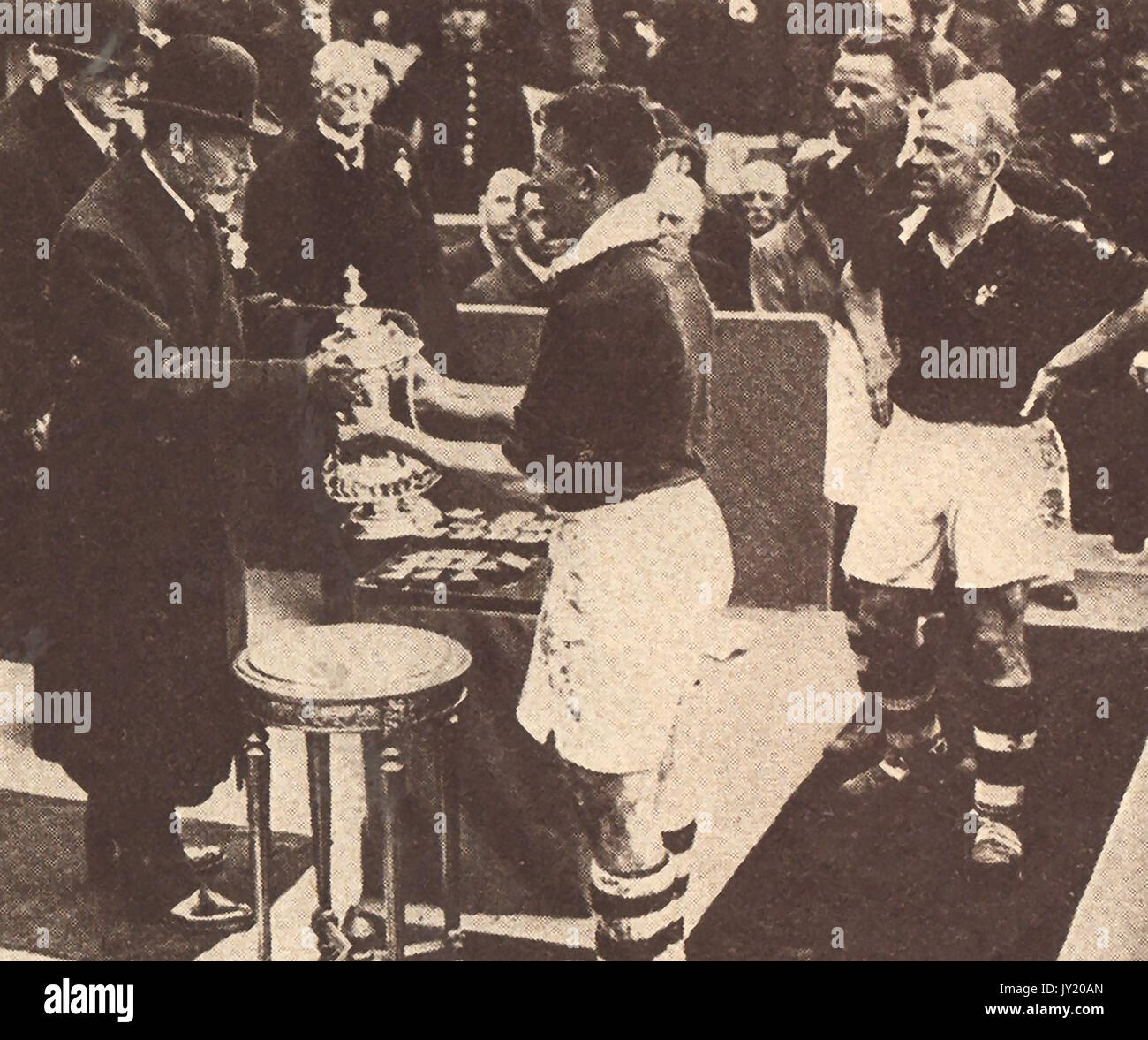 1934 - König George V. von England hier die Gewinner Schale an der AFC-Finale in Wembley, London, Kapitän, Sam Cowan von Manchester United, das schlug Portsmouth 2-1 zu Team. Stockfoto