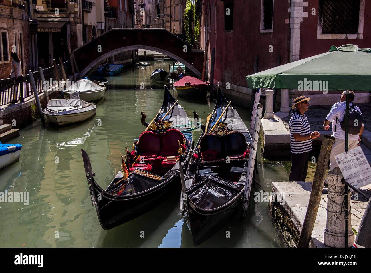 Venedig, Italien - 20 August 2015: Touristische und Gondoliere auf ein Gespräch über eine venezianische Straße durch Gondeln Stockfoto