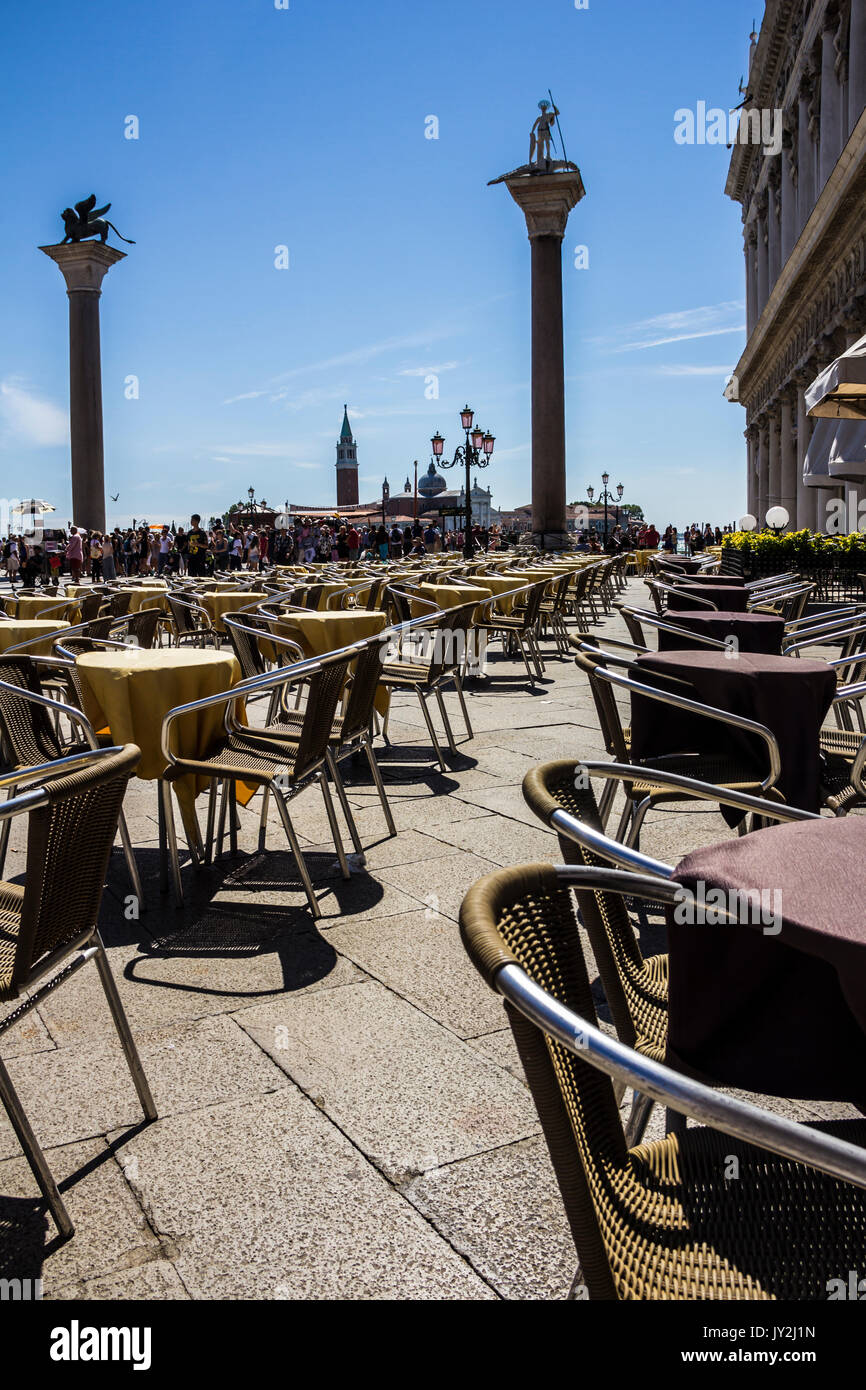 Street Café für Touristen in San Marco Platz mit Blick von San Marco und San Todaro Spalten in Venedig, Italien warten Stockfoto
