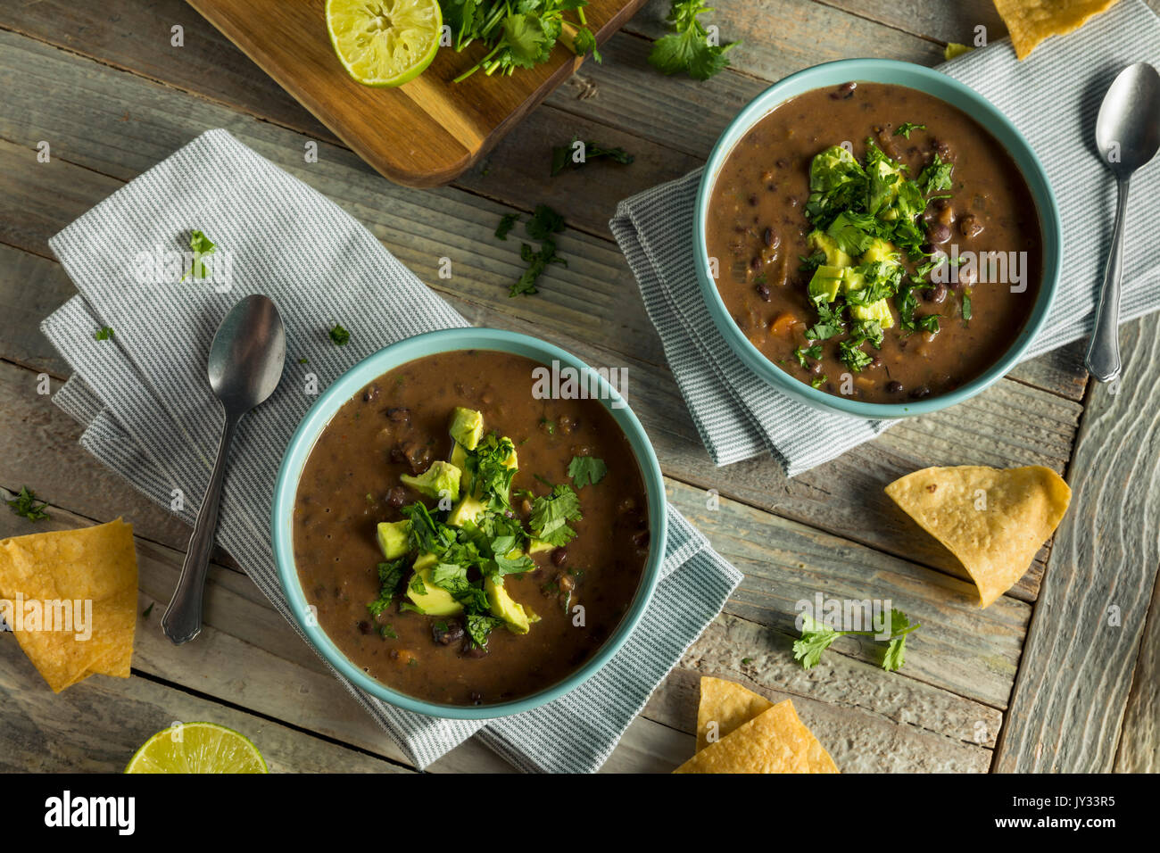 Frische hausgemachte schwarze Bohnensuppe mit Avocado und Koriander Stockfoto
