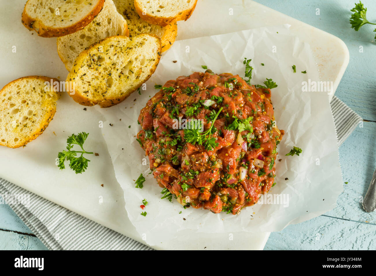 Raw Organic French Beef Tartare mit Scheiben Brot Stockfoto