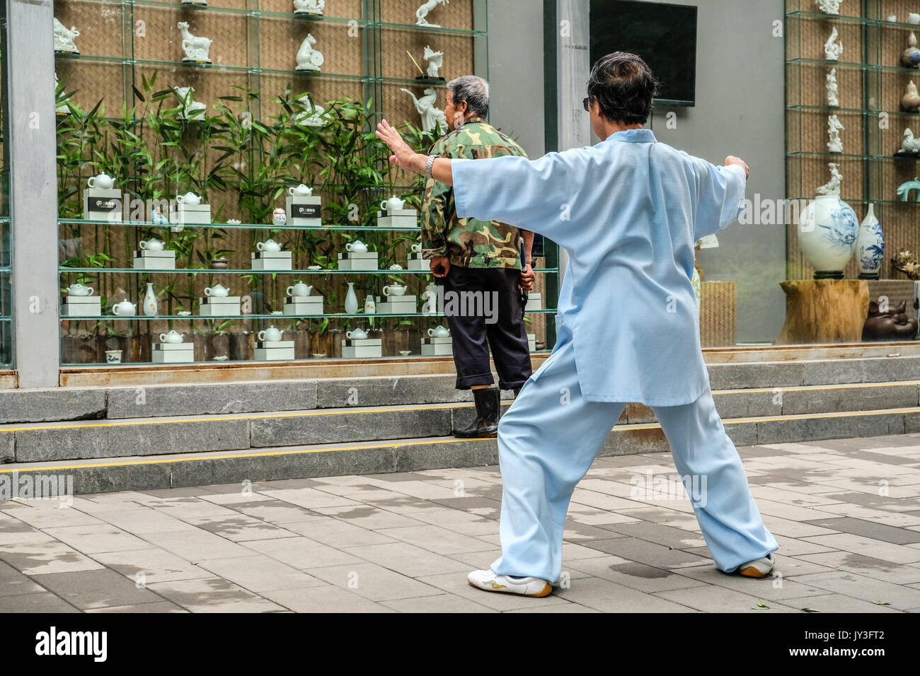 Ein chinesischer Mann in der Traditionellen Chinesischen dressing üben Tai Ji im Yu Yuan Tan Park in Peking, China Stockfoto